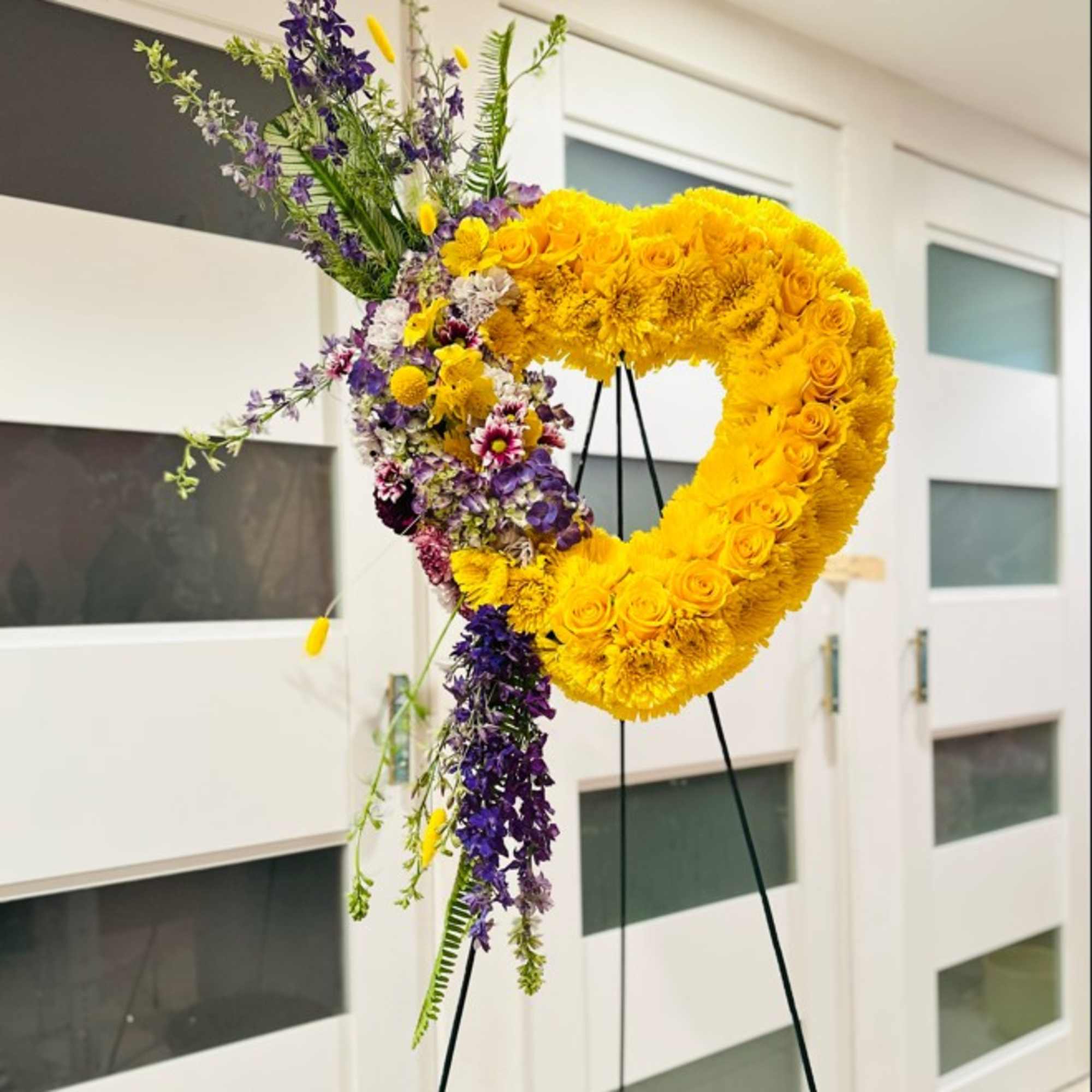 Bright heart set with yellow roses and mums to honor your loved