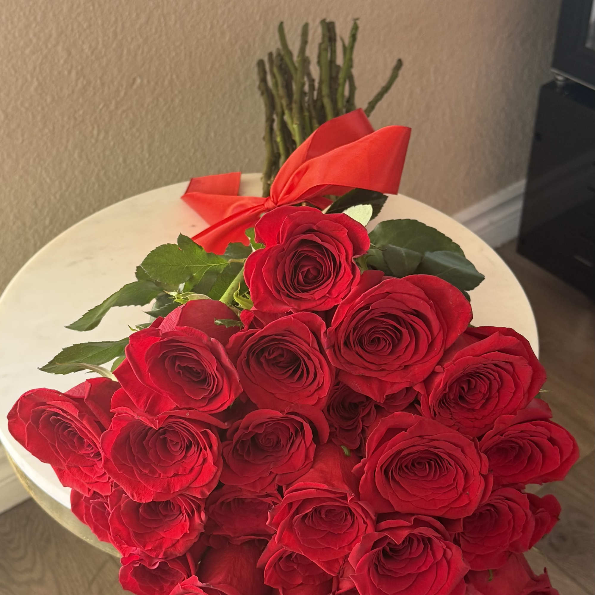 Twenty-four premium long-stem red roses beautifully hand-tied and wrapped with a luxurious