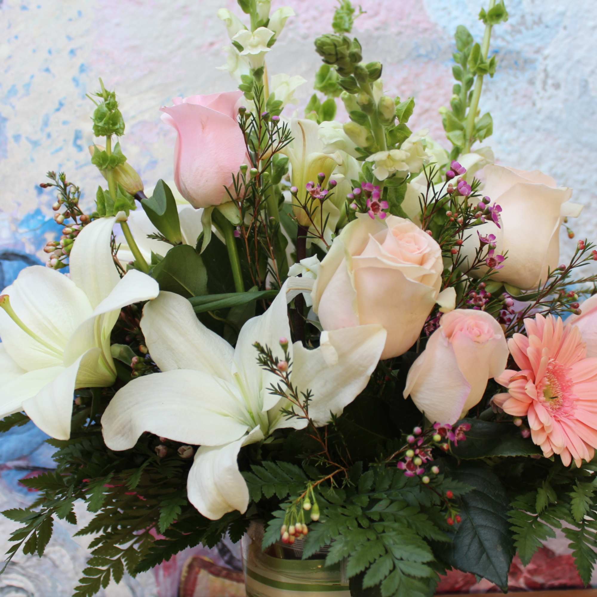 glass vase arrangement may included, light pink roses, gerberas daisies, german bells