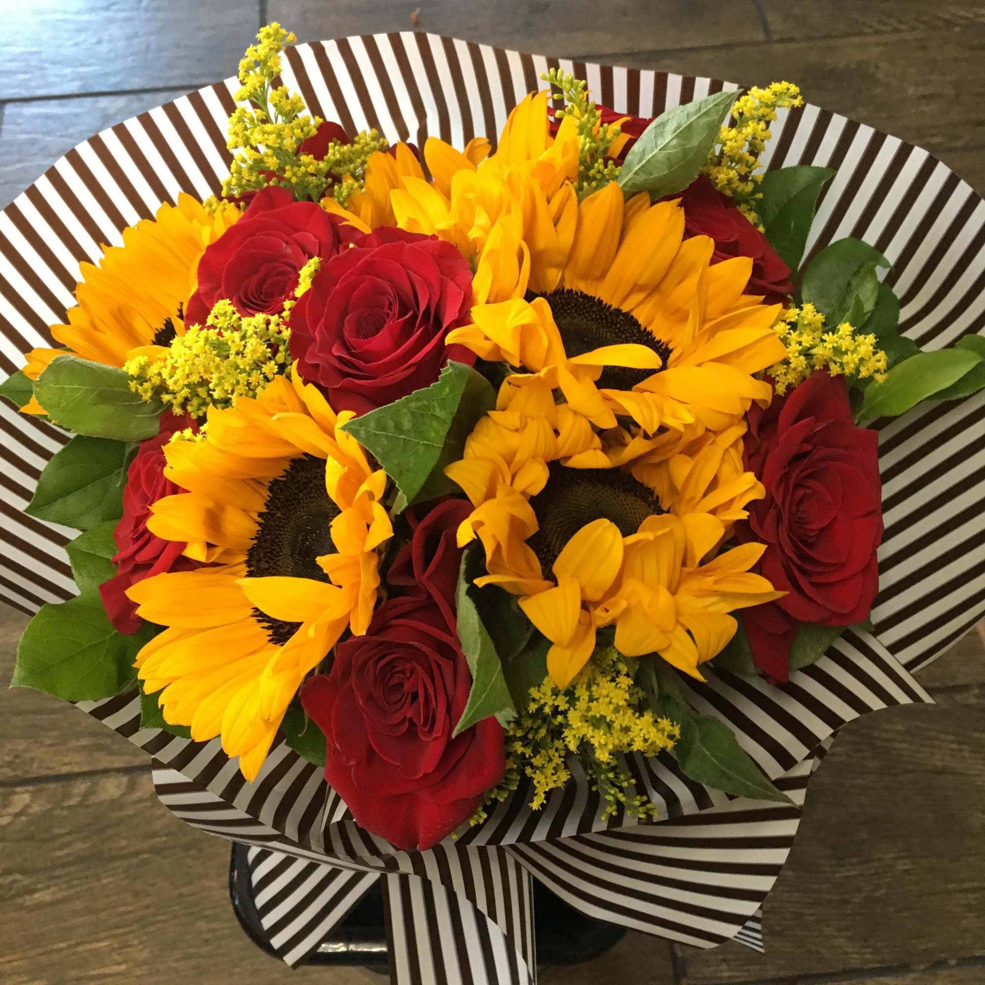 Hand tie bouquet may consist of sunflower, roses, solidaster, and foliage 
Note: