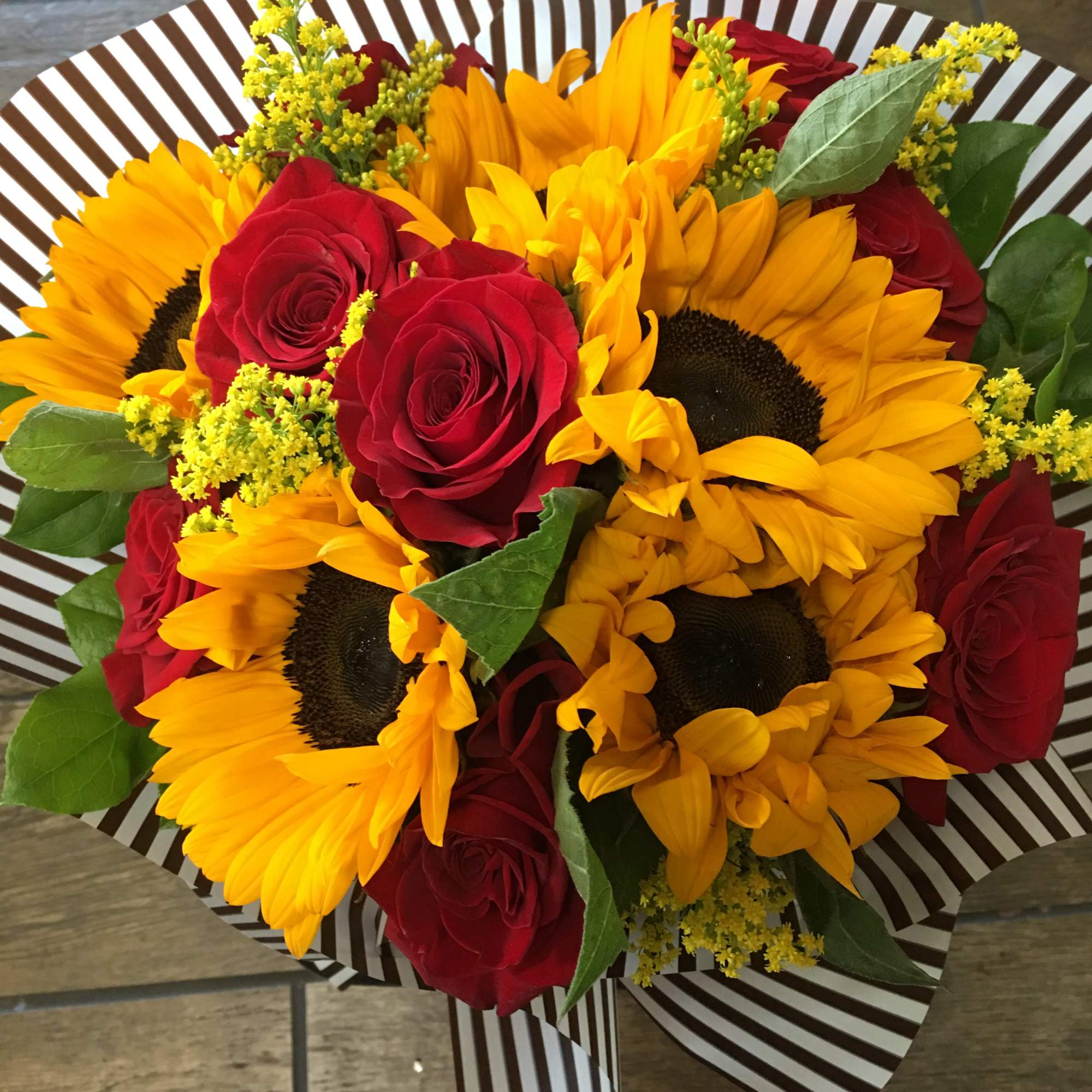 Hand tie bouquet may consist of sunflower, roses, solidaster, and foliage 
Note: