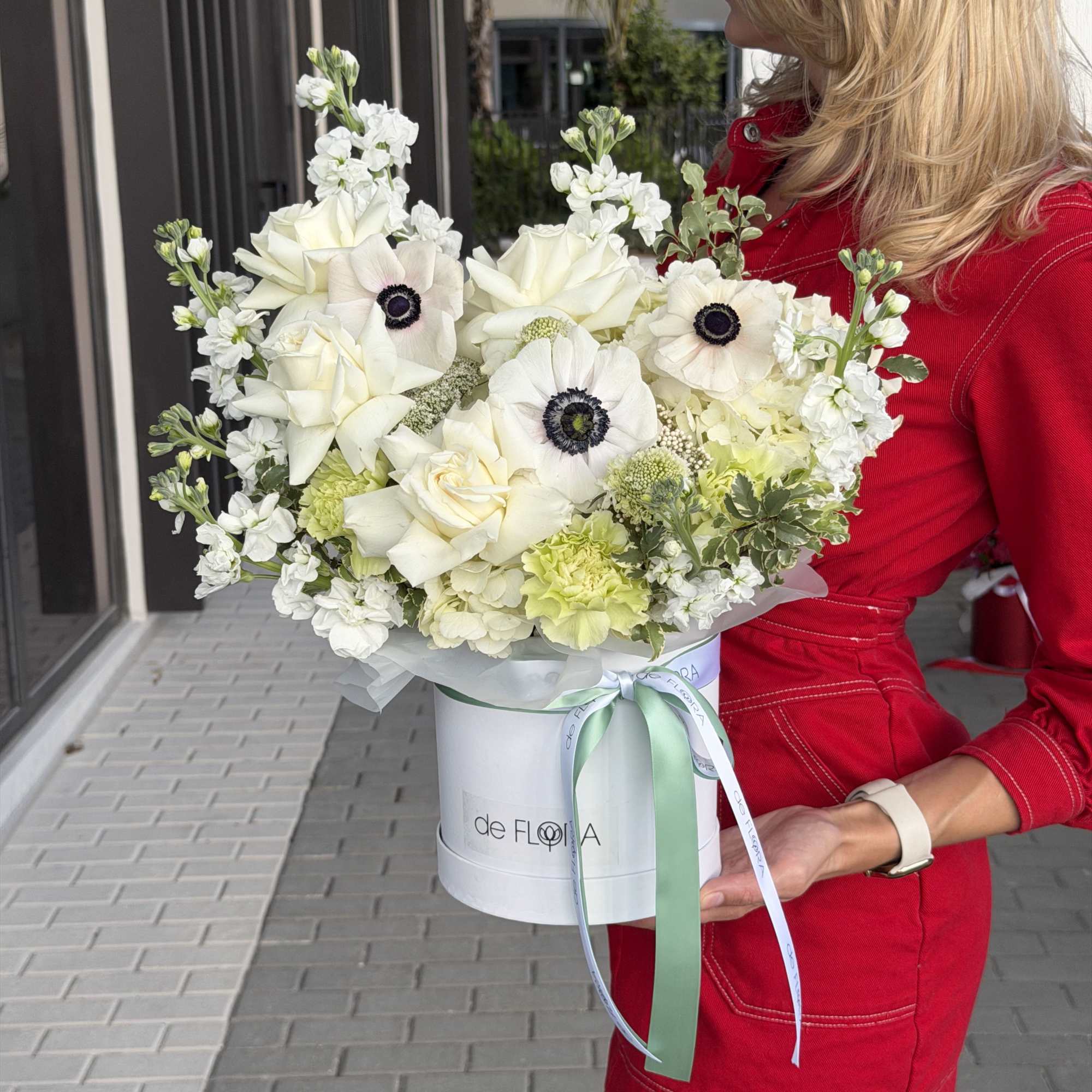 An exquisite arrangement of creamy white roses, delicate anemones with deep contrasting