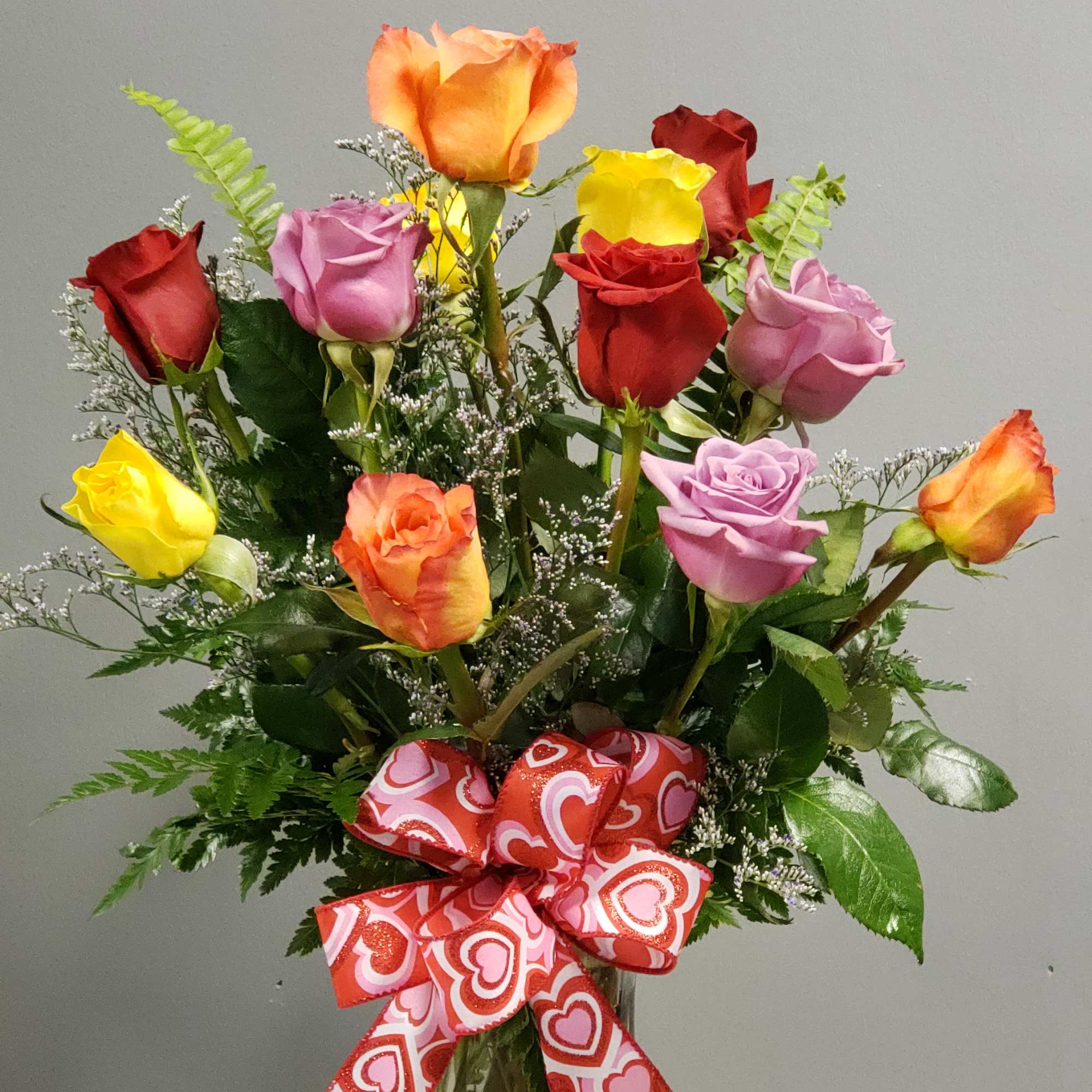 12 premium roses vased with eucalyptus, fern, salal leaves and babies breath.