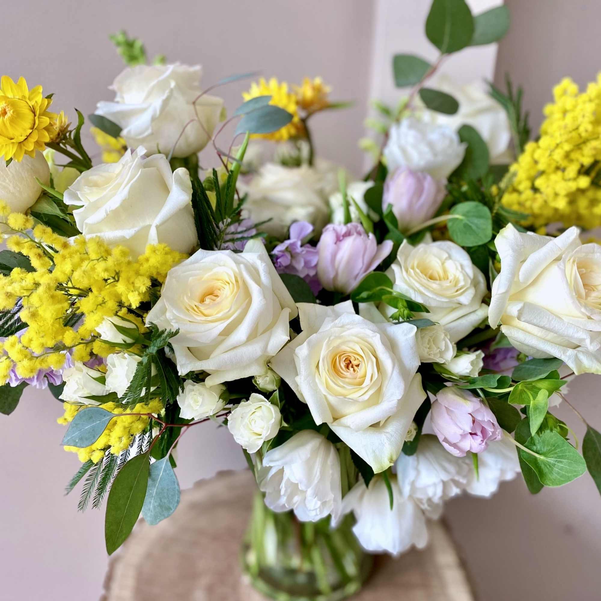 A gorgeous bouquet filled with white roses, tulips, lavender stock, and fragrant