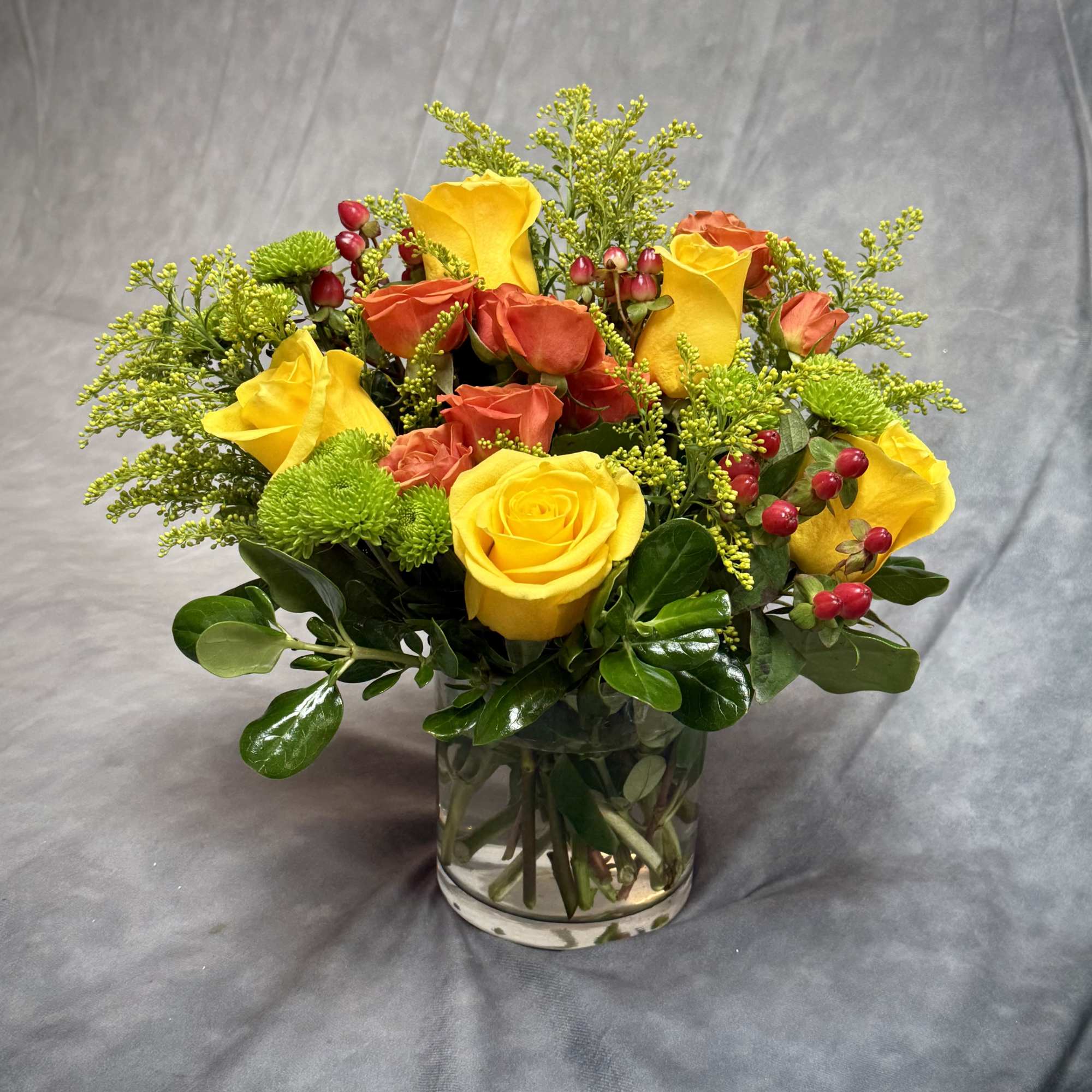 A vibrant and lively arrangement of yellow and orange roses , lime