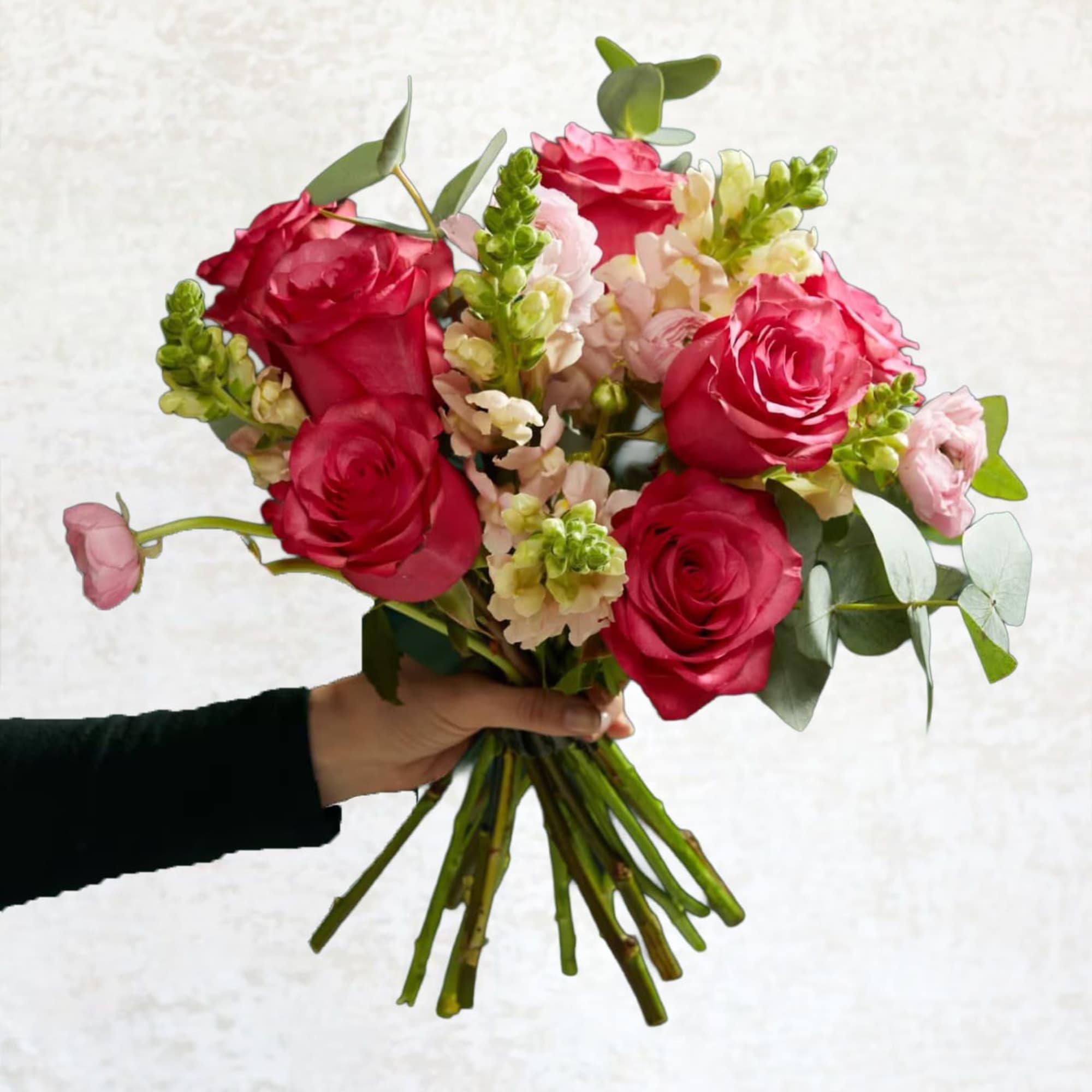 Handheld bouquet of pink roses and pale snapdragons