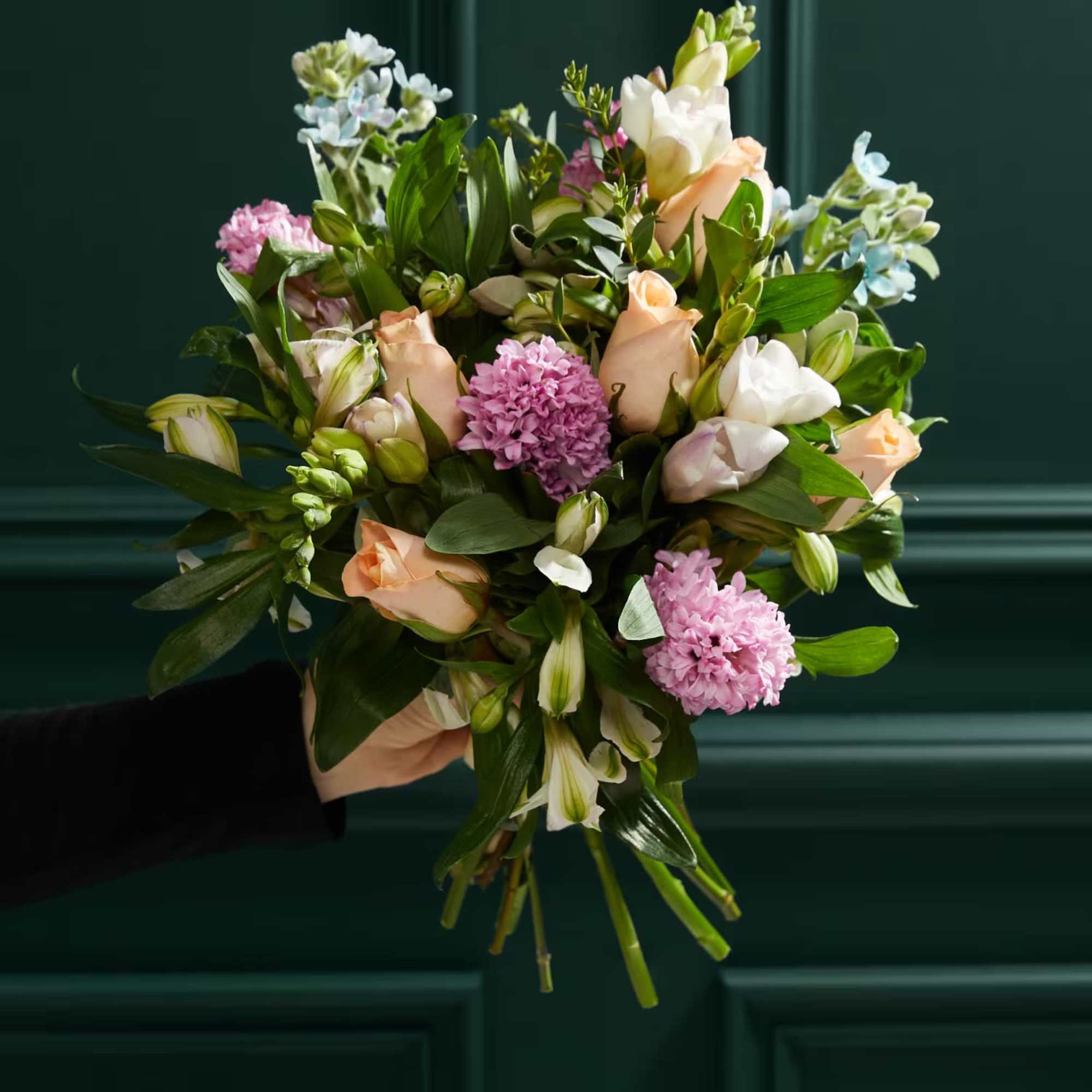 Hand-tied bouquet of peach and white flowers with pink blooms