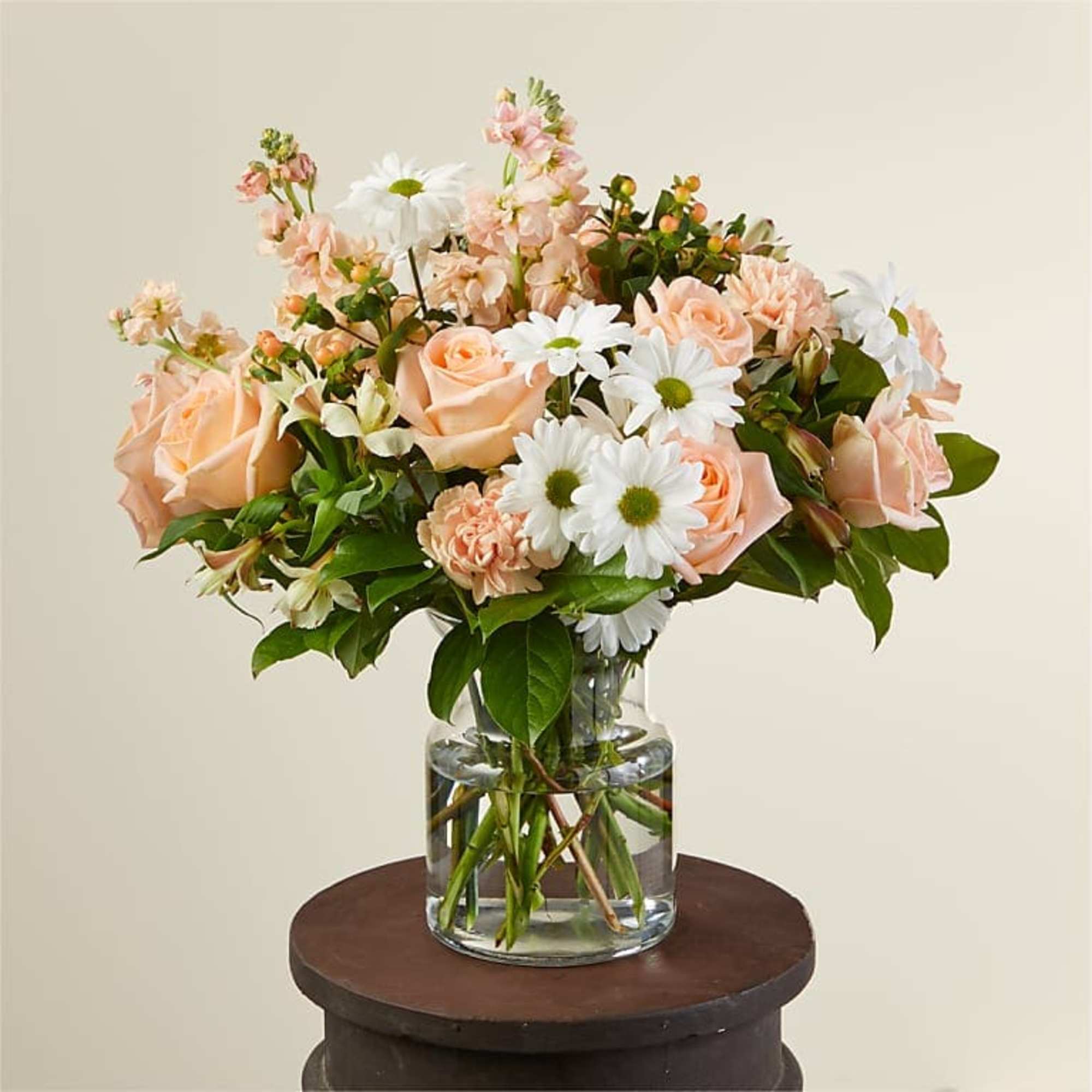 This delicate arrangement features an assortment of carnations, roses, daisies, and assorted