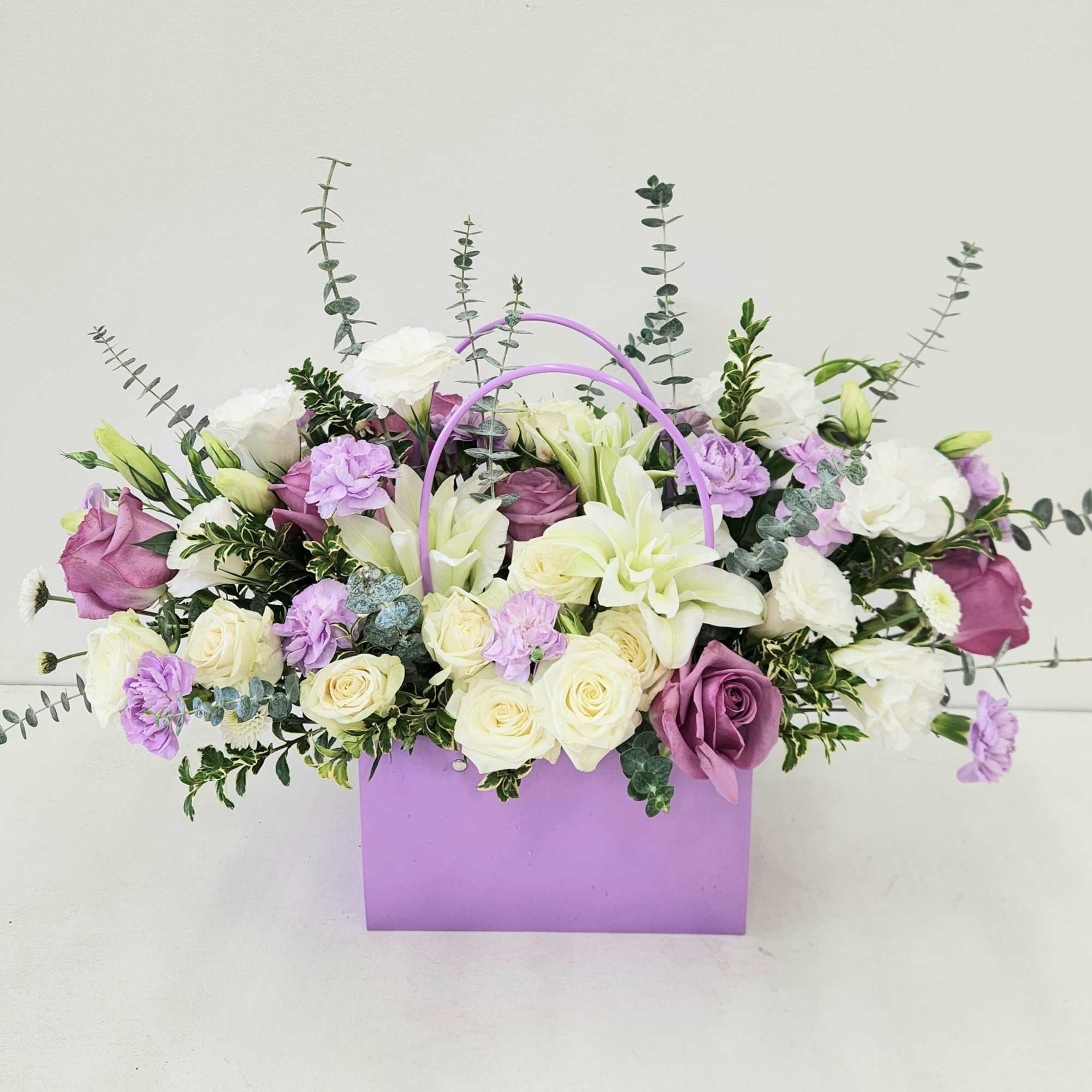 An elegant and unique bouquet of fresh roses and lilies, beautifully arranged