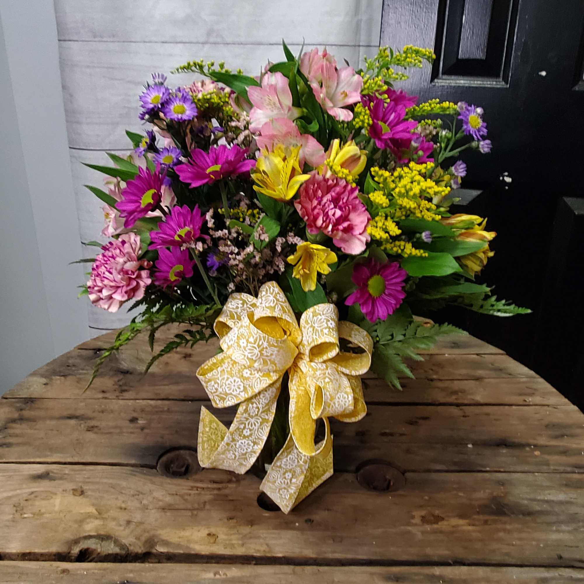 This is a vibrant and cheerful floral arrangement that exudes energy and