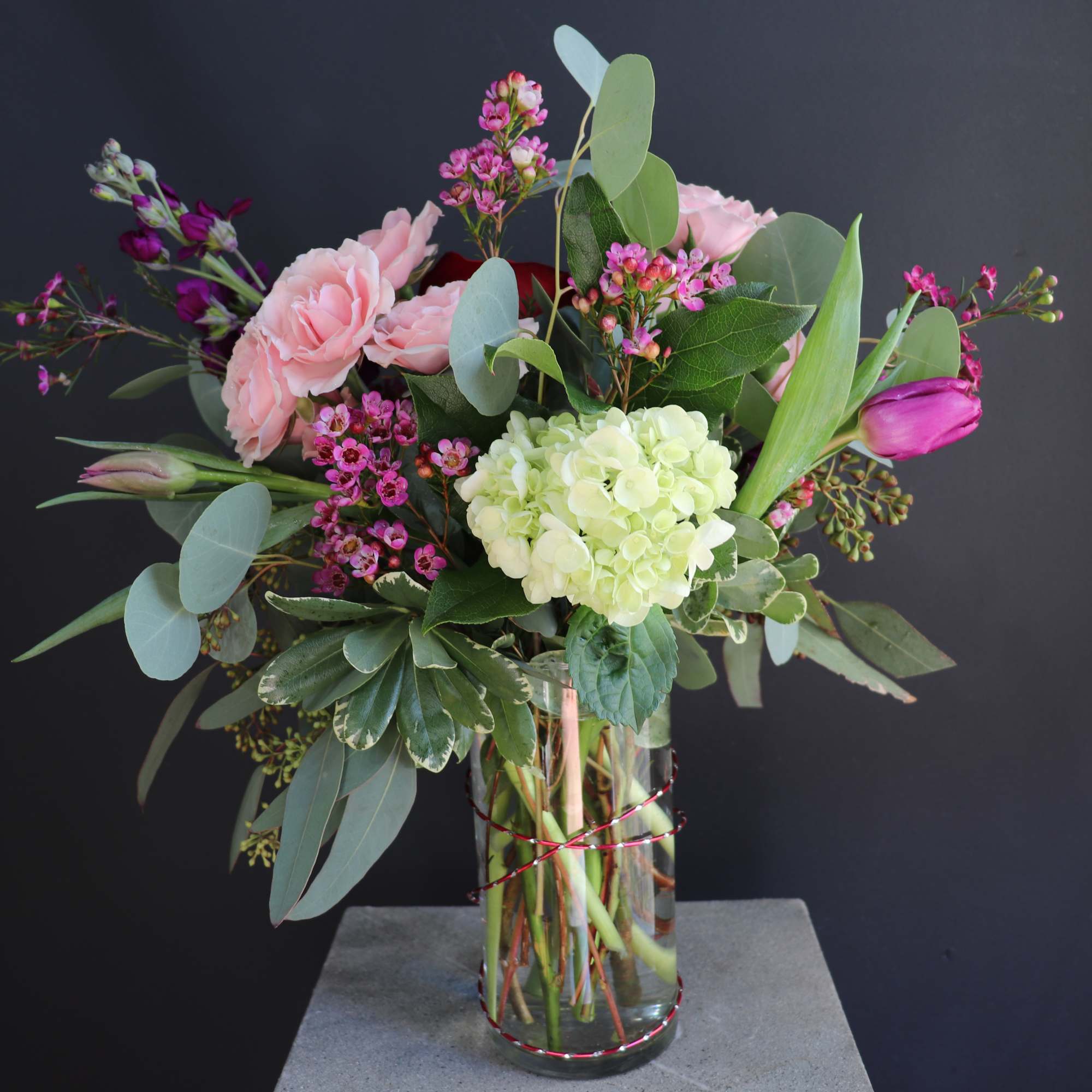 A beautiful arrangement of love with tulips, roses, hydrangea, and wax flowers