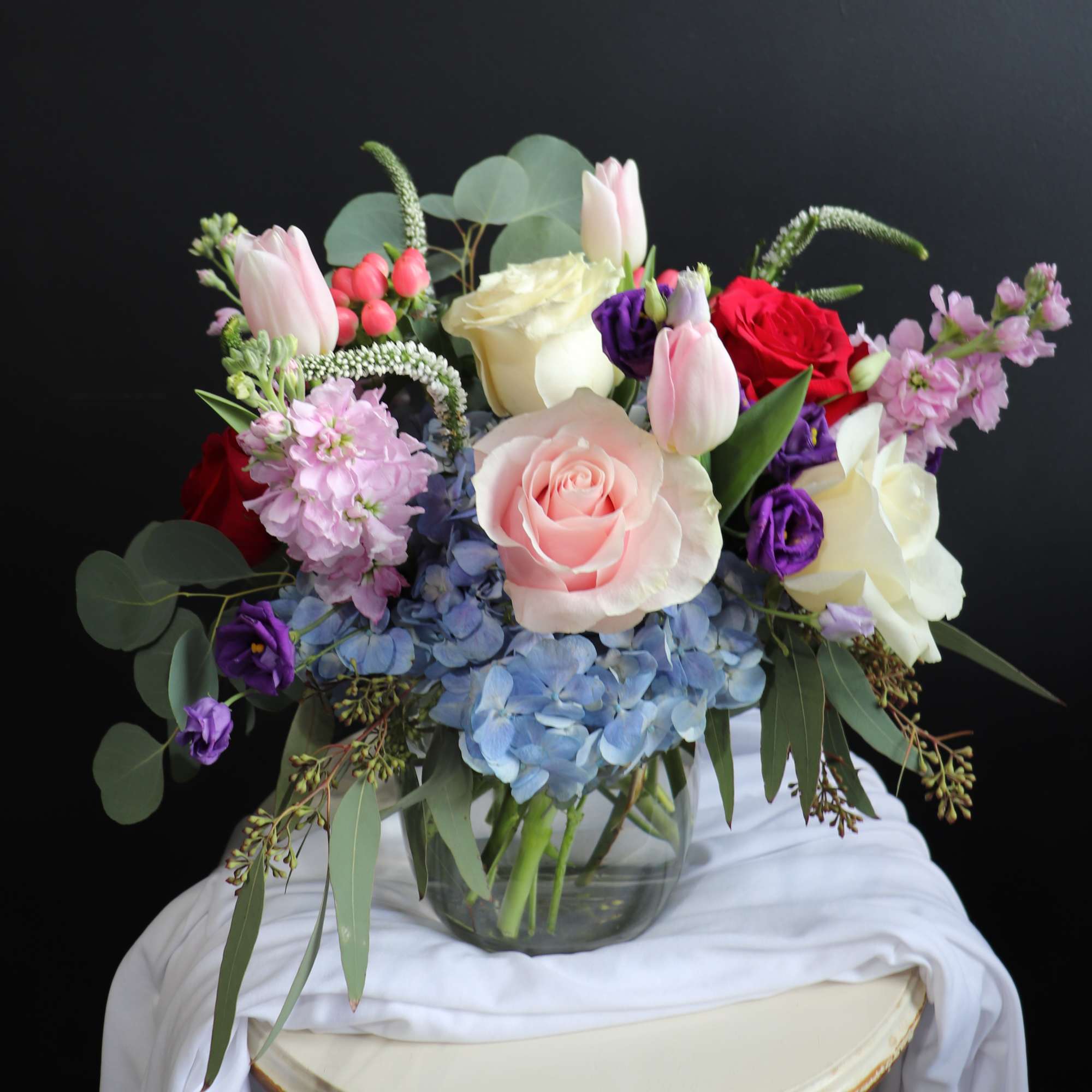 A glass vase arrangement full of color and life with lots of