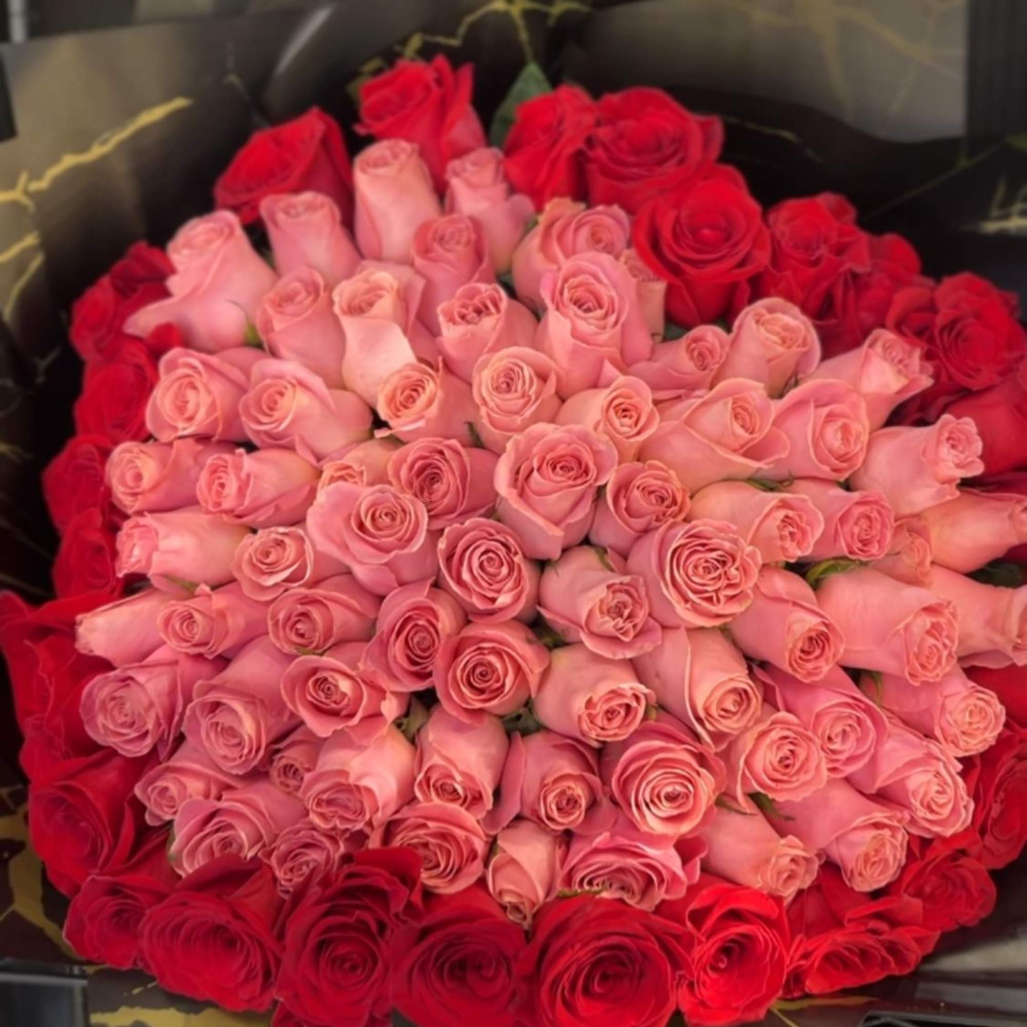 averages 100 total roses in a heart shape; a pink center with
