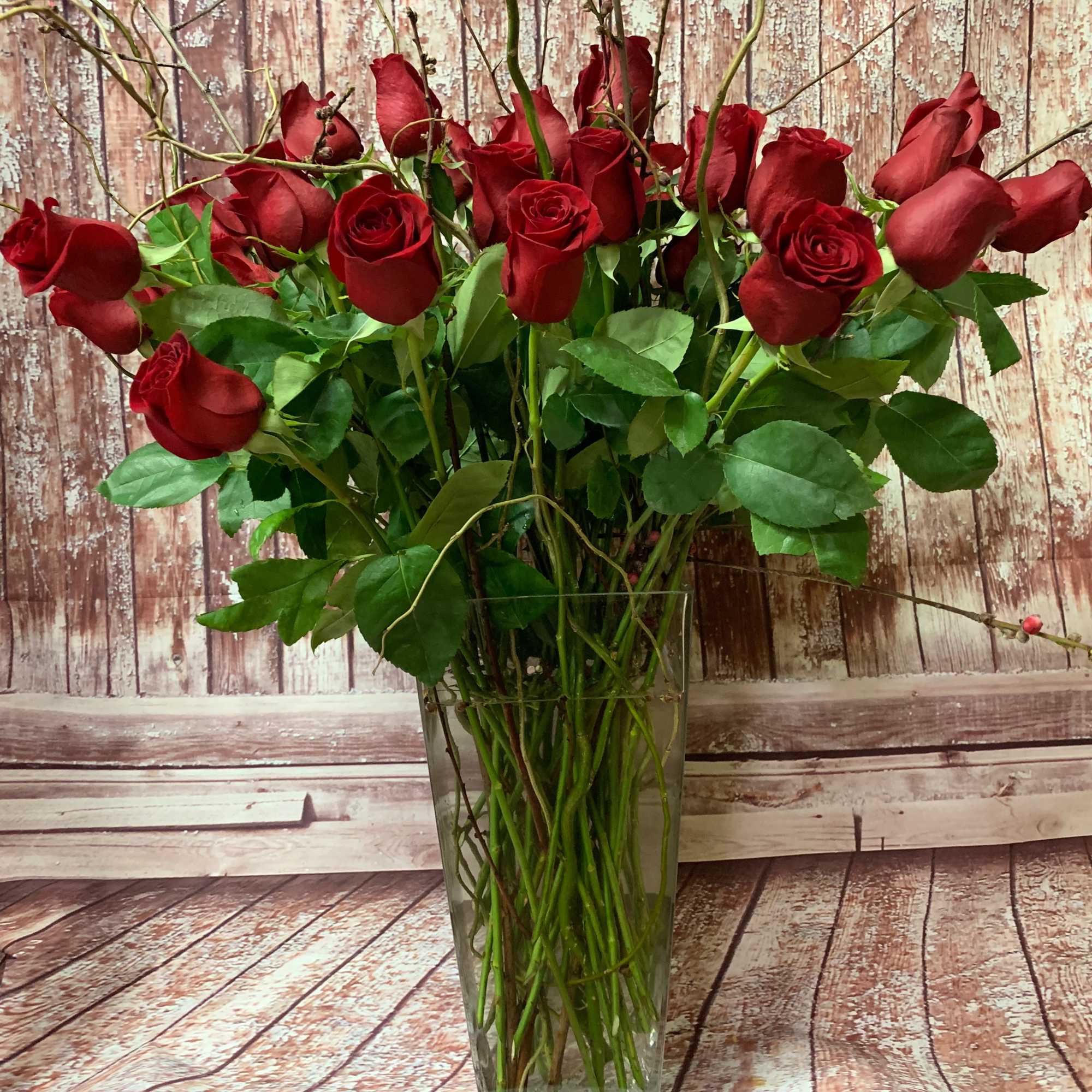 Beautiful long-stemmed red roses presented in a high quality clear glass or