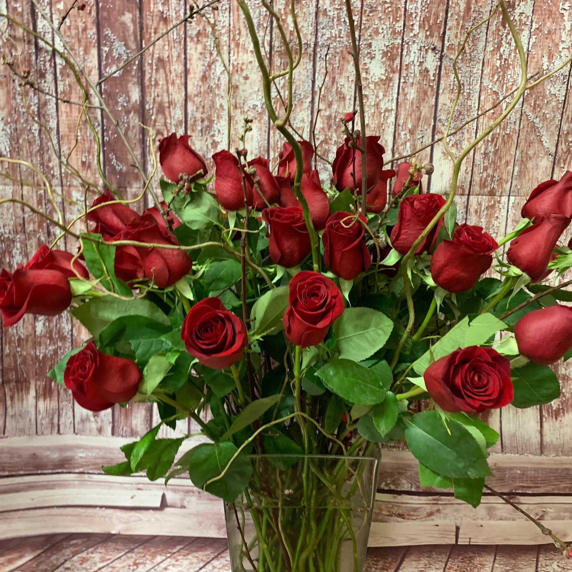 Beautiful long-stemmed red roses presented in a high quality clear glass or