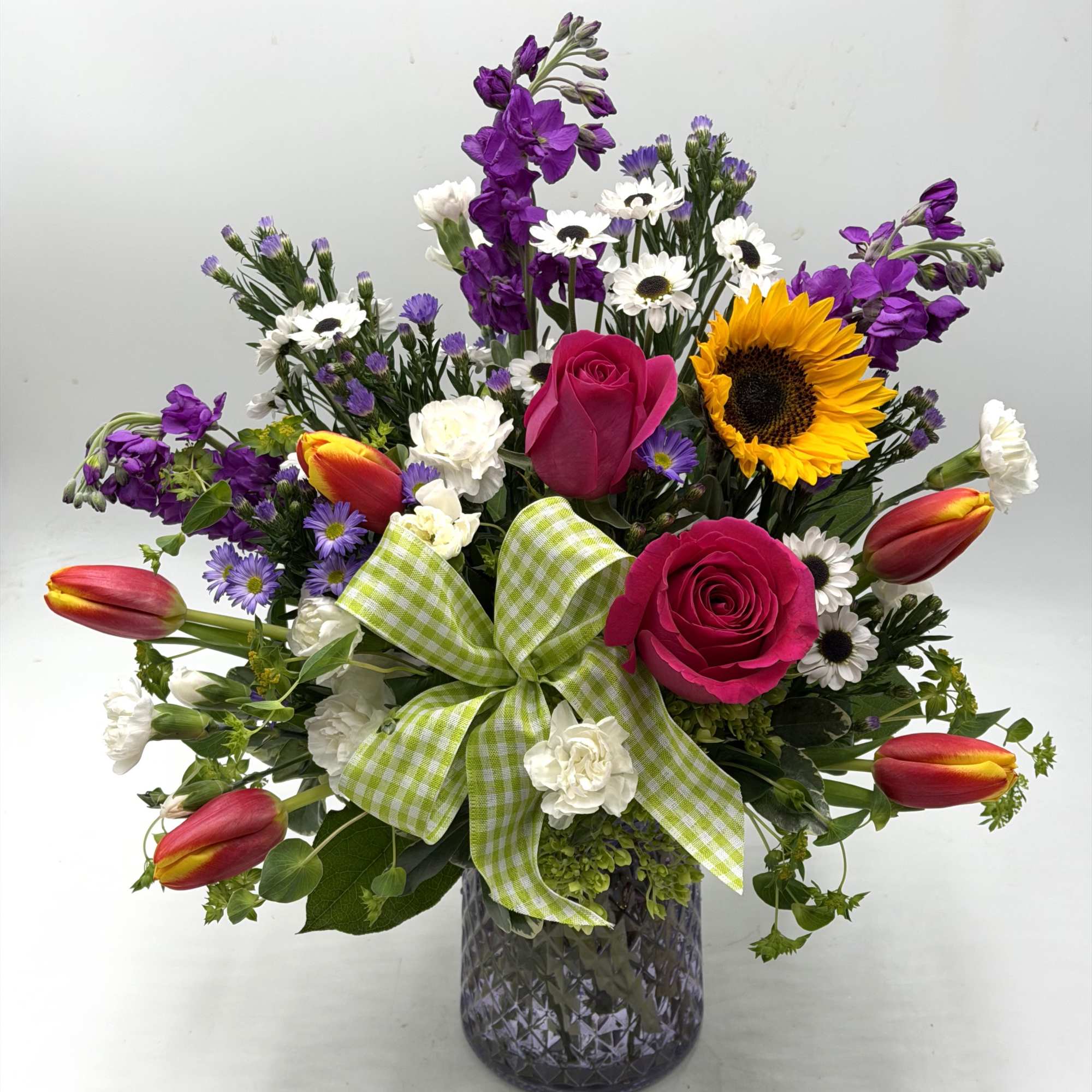 Bright &amp; Uplifting, this lively garden-style arrangement blends bold pink roses, sunny