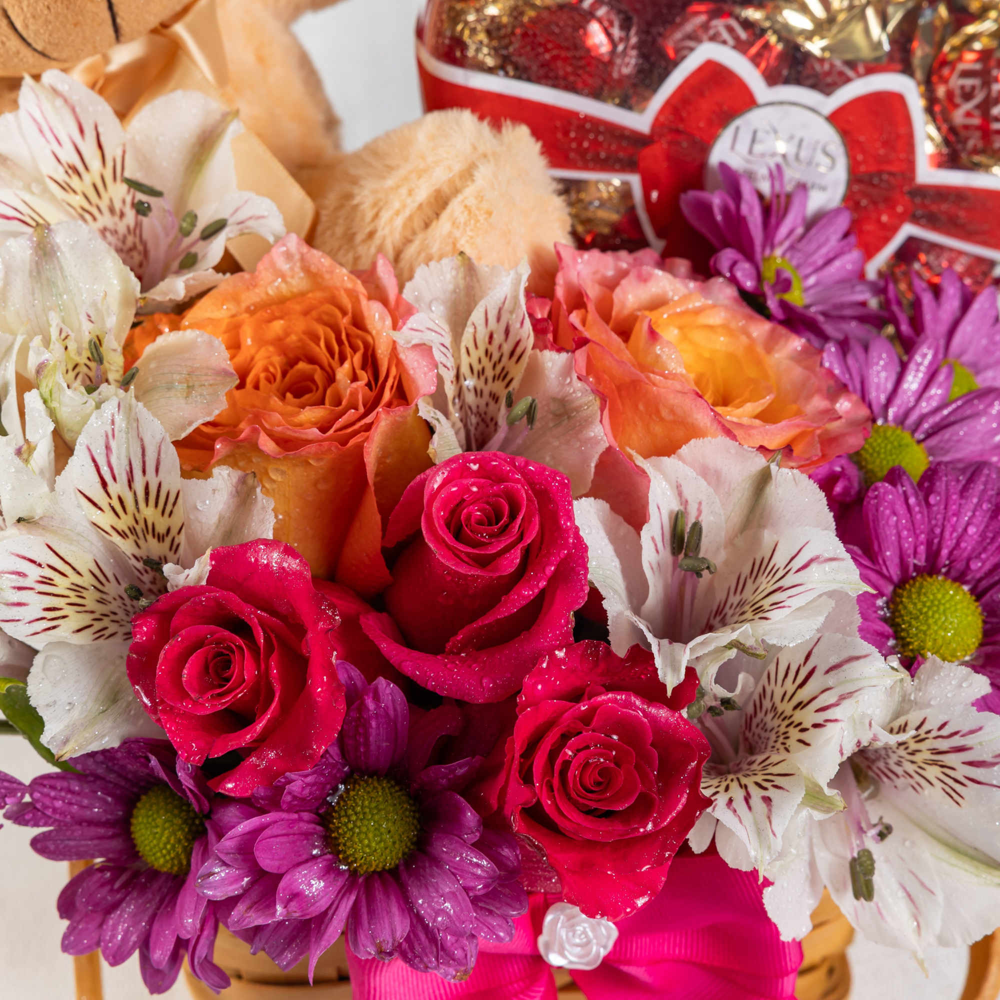 A heartwarming gift basket filled with pink daisies, alstroemerias, and orange roses