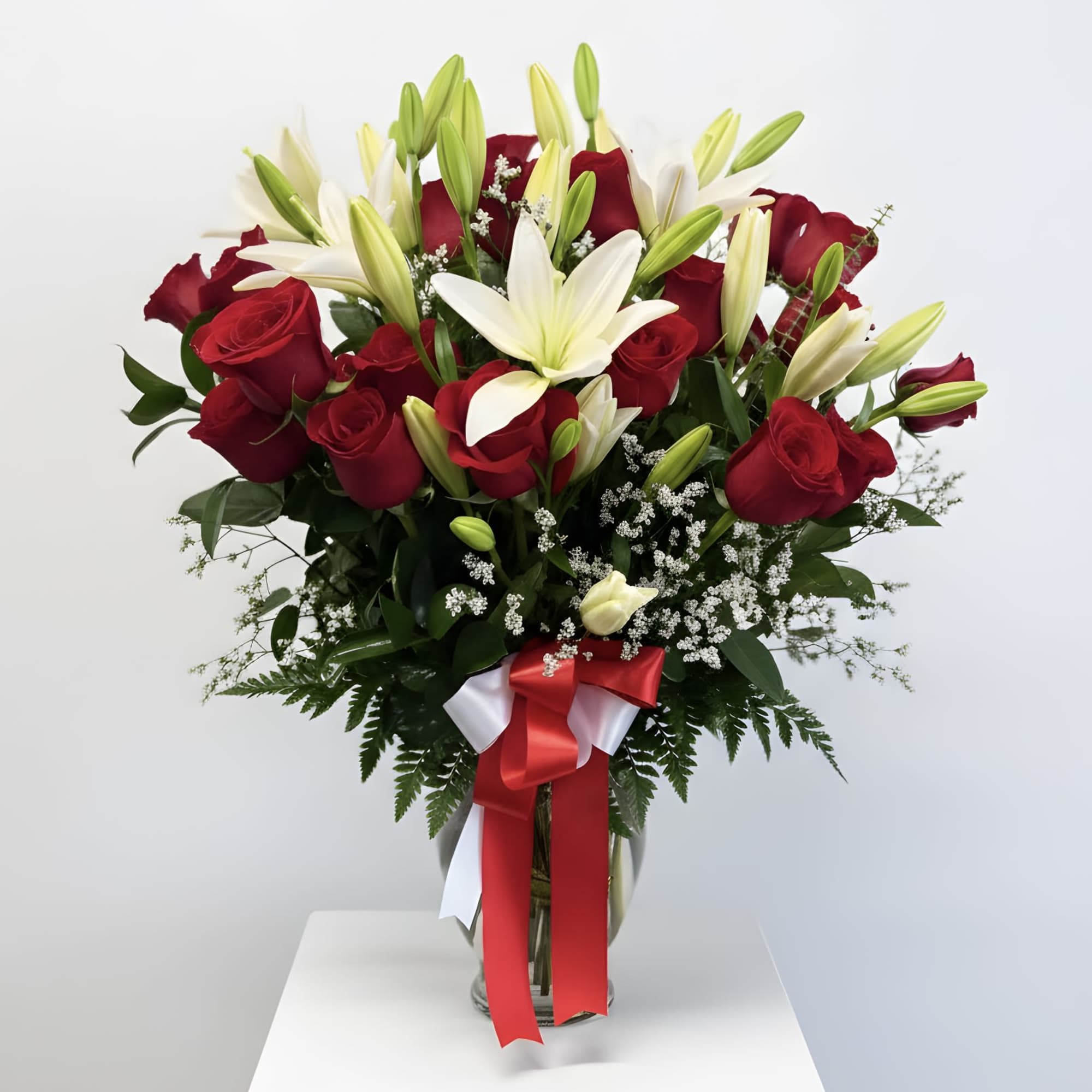 Beautiful fresh red roses paired with elegant white lilies, arranged in a