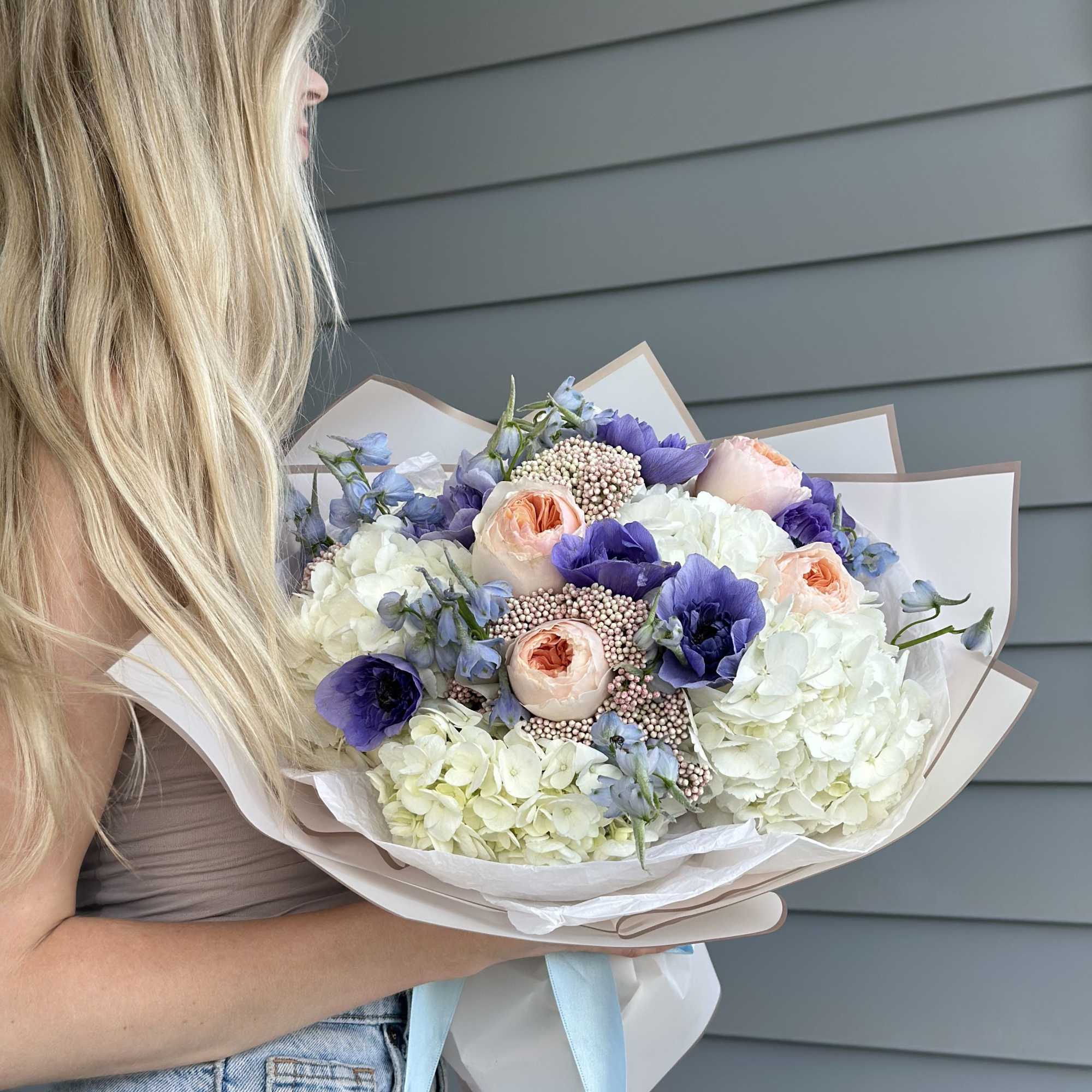 A dreamy blend of creamy hydrangeas, peach garden roses, and deep violet