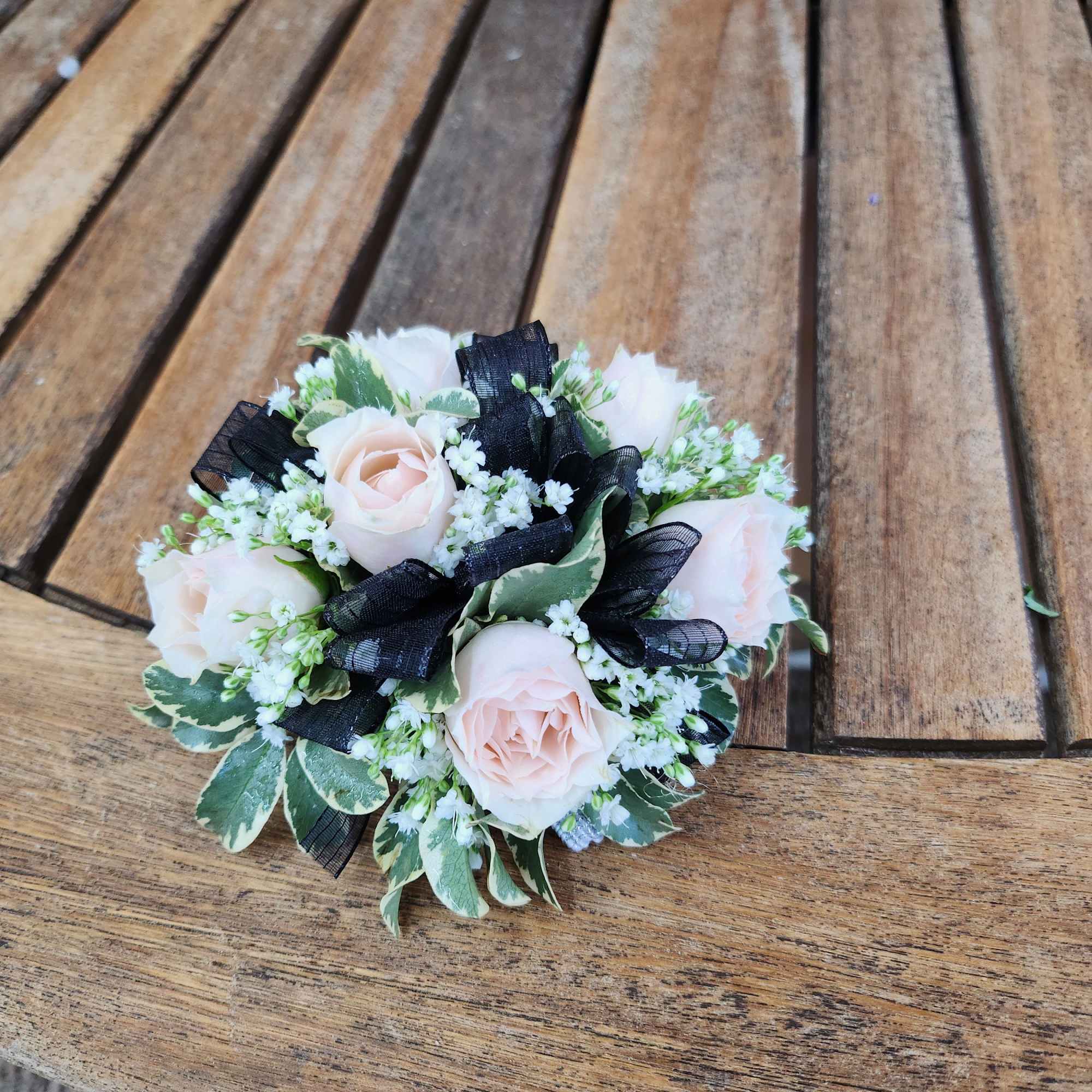 Wrist Corsage With Blush Spray roses, greenery, filler flower and black ribbon.
