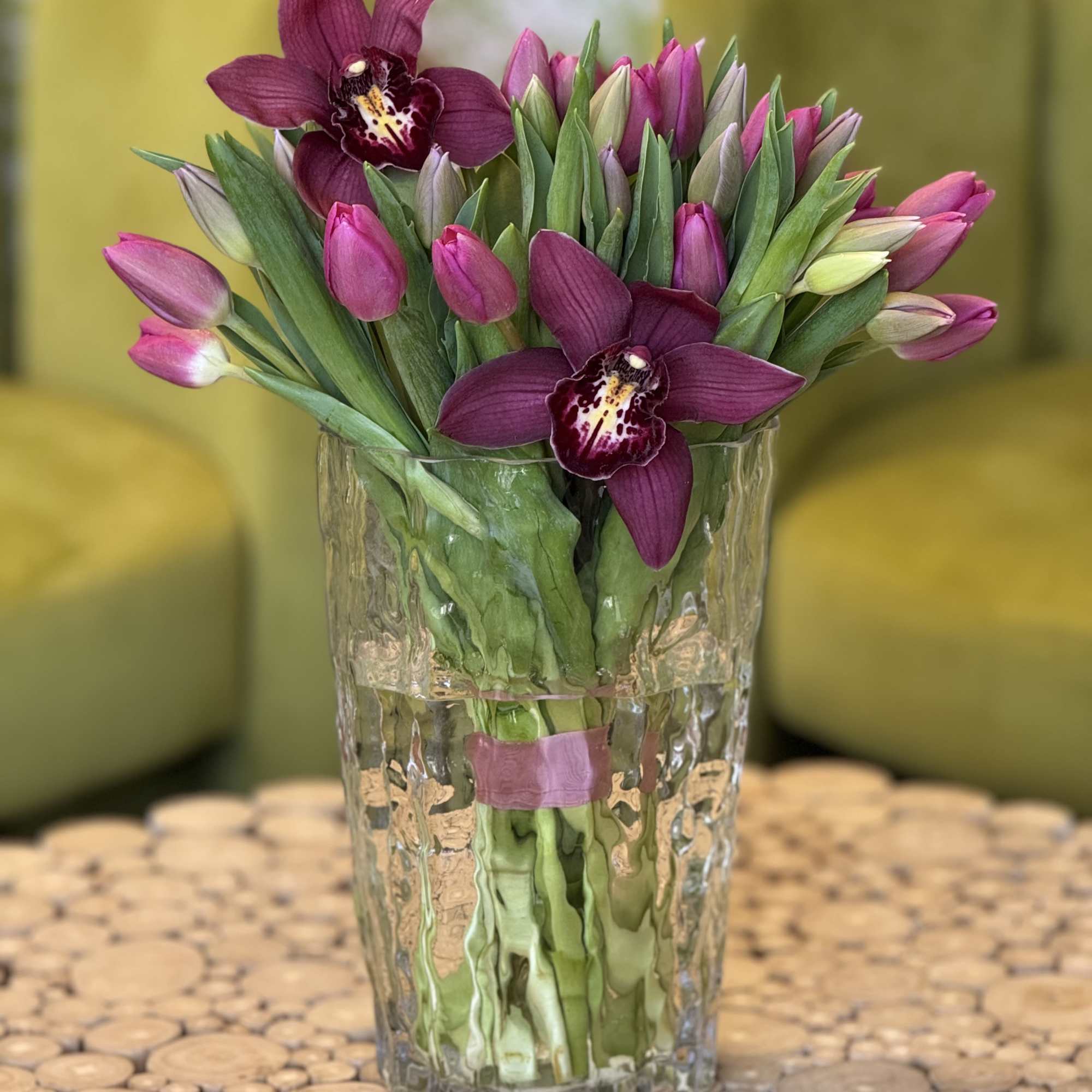 A graceful arrangement of fresh pink tulips paired with deep burgundy orchids