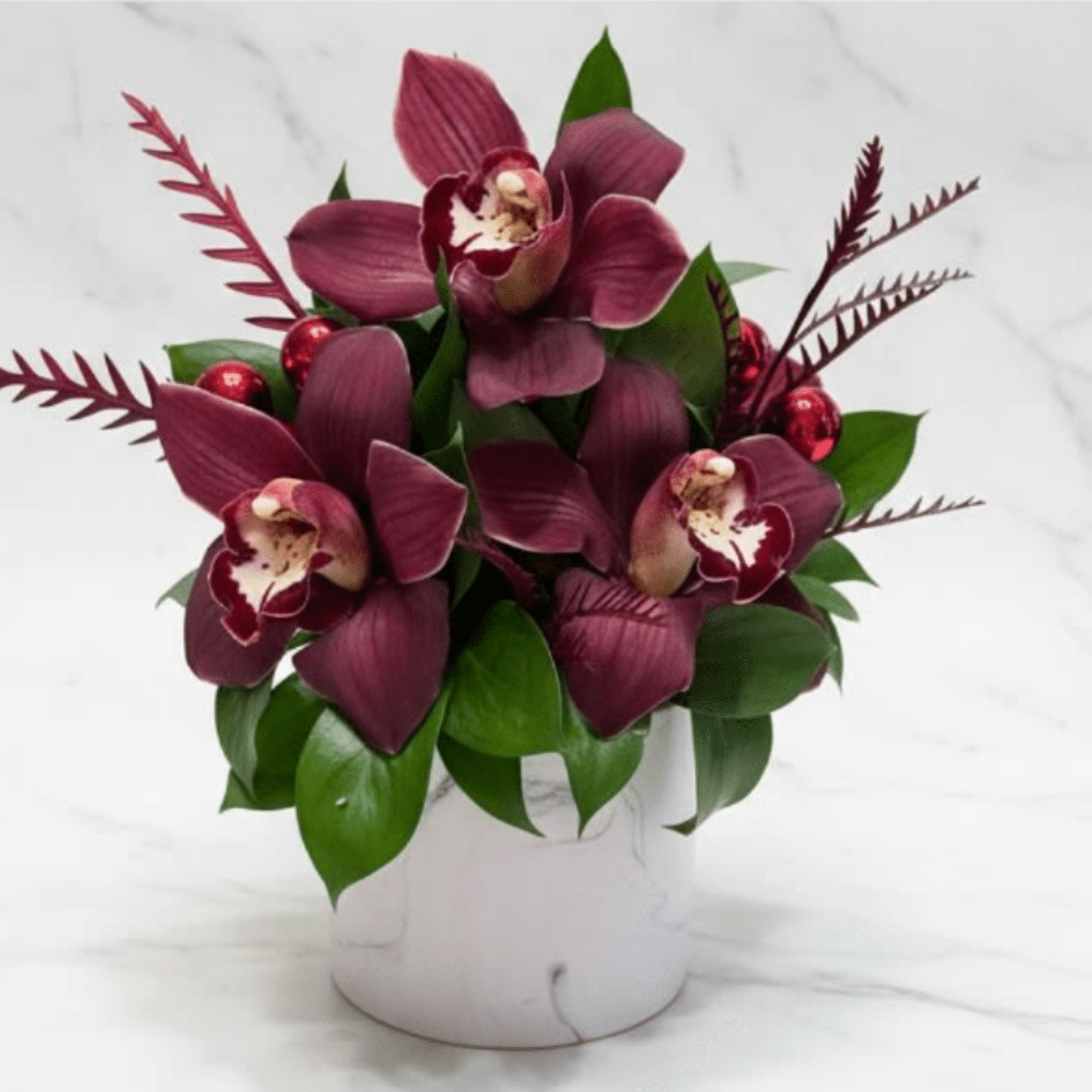 5-6 Cymbidium Orchids and hearty greens is a marble vase.  Perfect
