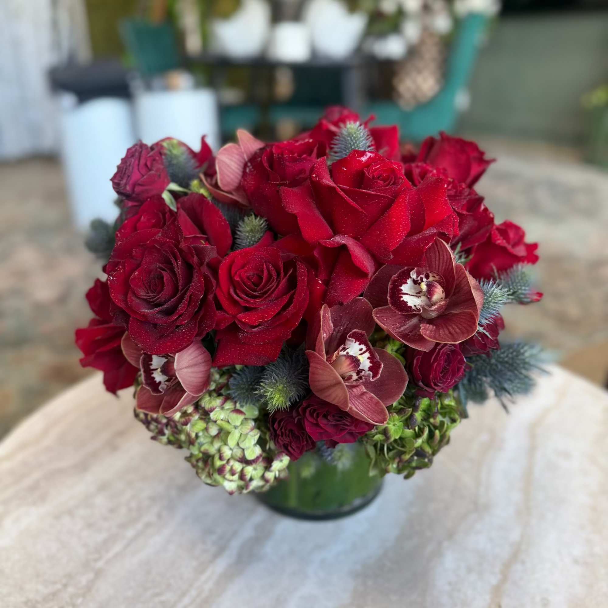 This arrangement features gorgeous burgundy Roses set in vintage green Hydrangea, with