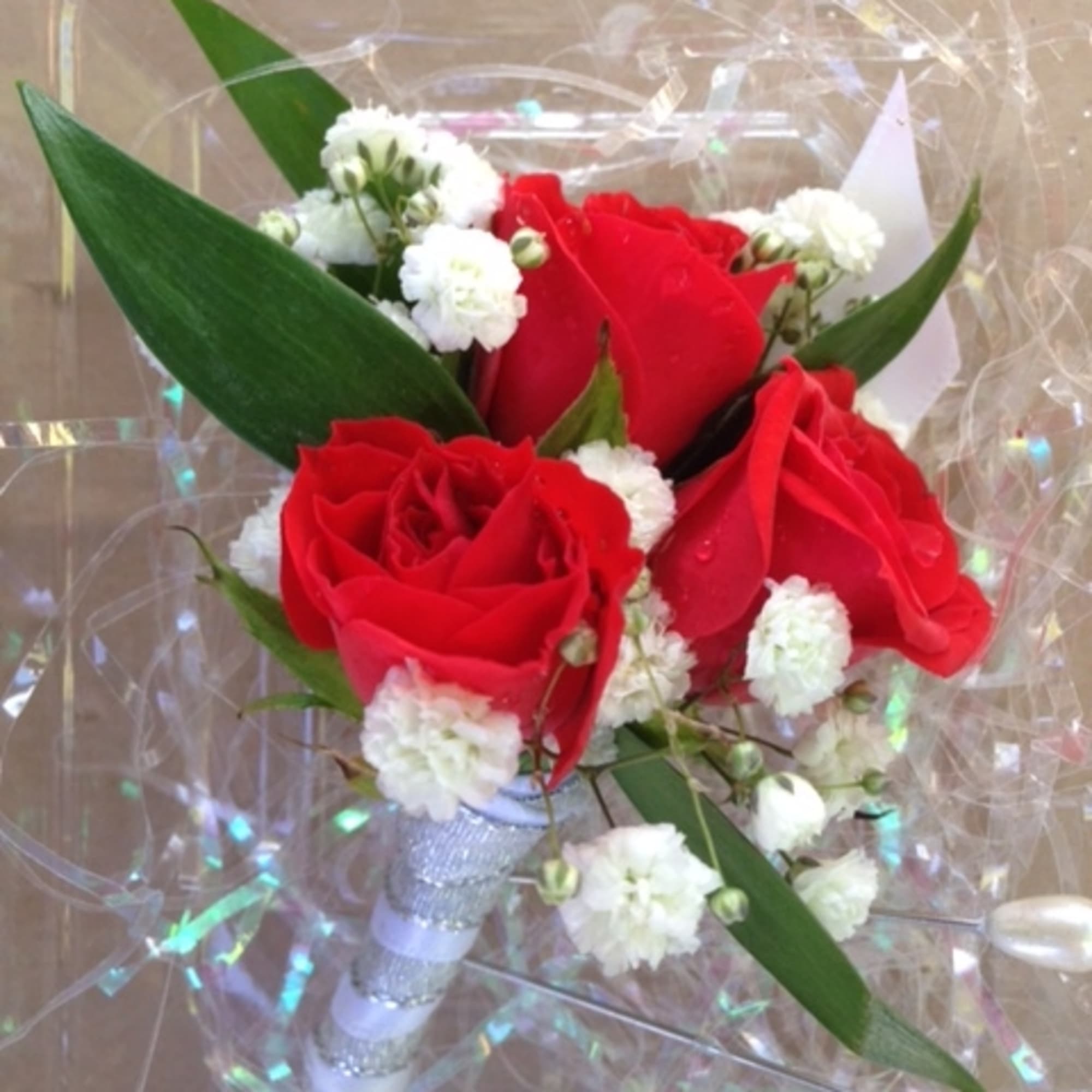 Red roses with white filler flowers in a wrapped bouquet