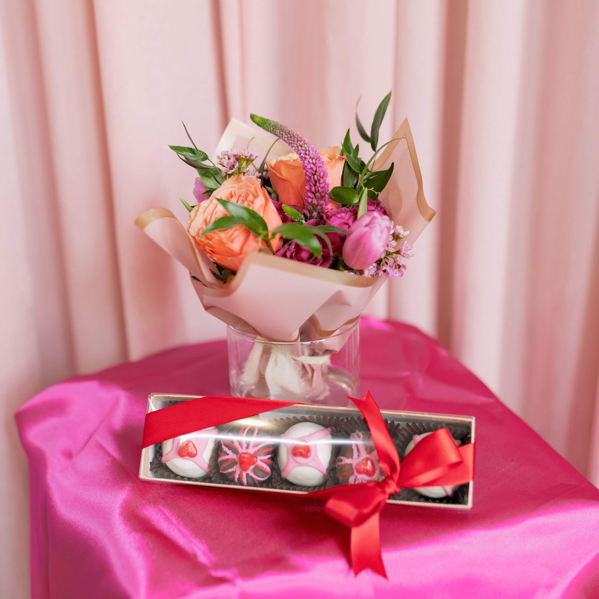 Fudge truffles with a pink and red floral arrangement arrives in a
