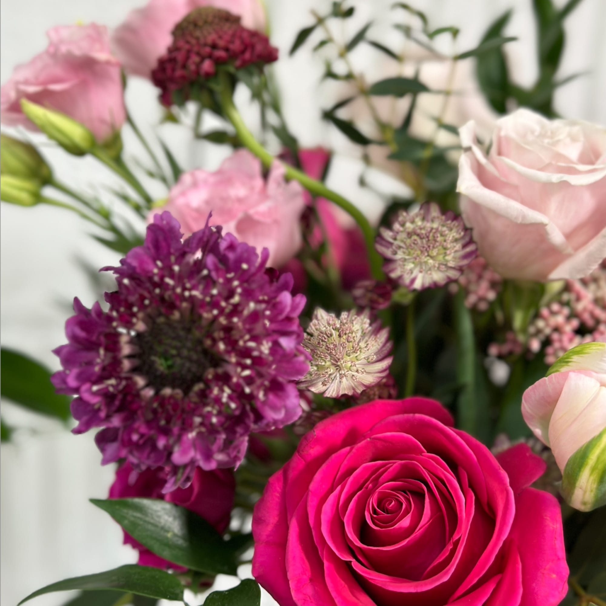 Bouquet of pink and purple flowers with a bright pink rose in front