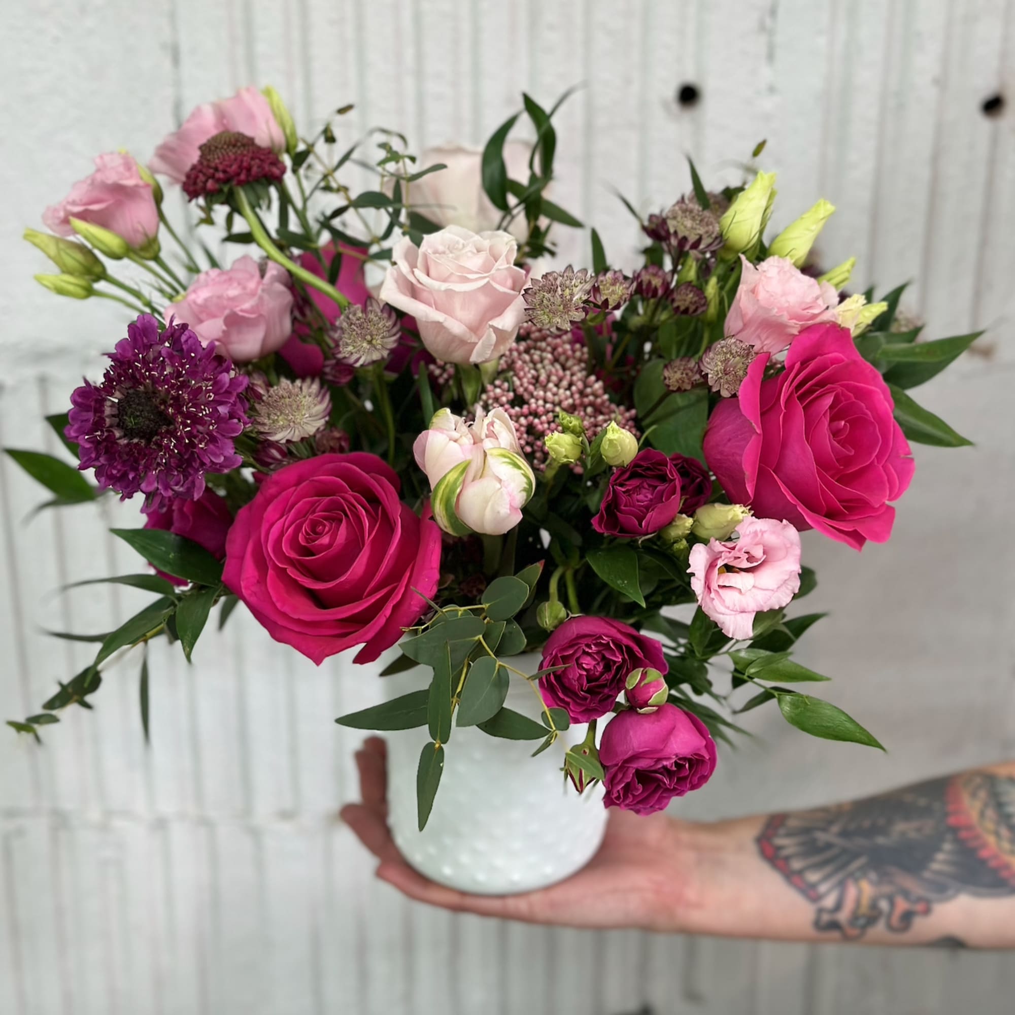 Pink and purple rose bouquet in a white vase
