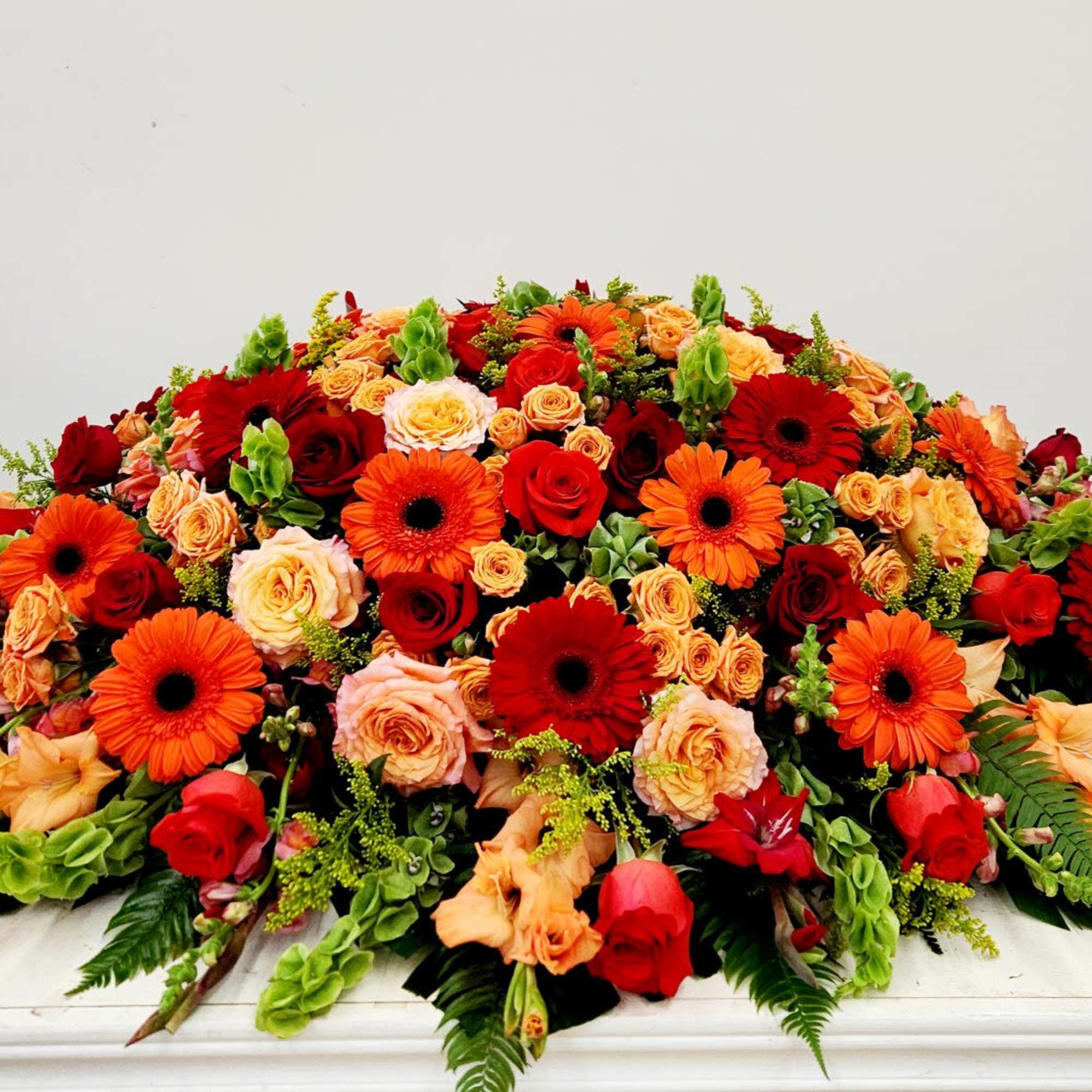 Celebrate a vibrant life well lived with the Colorful Remembrance Casket Spray.