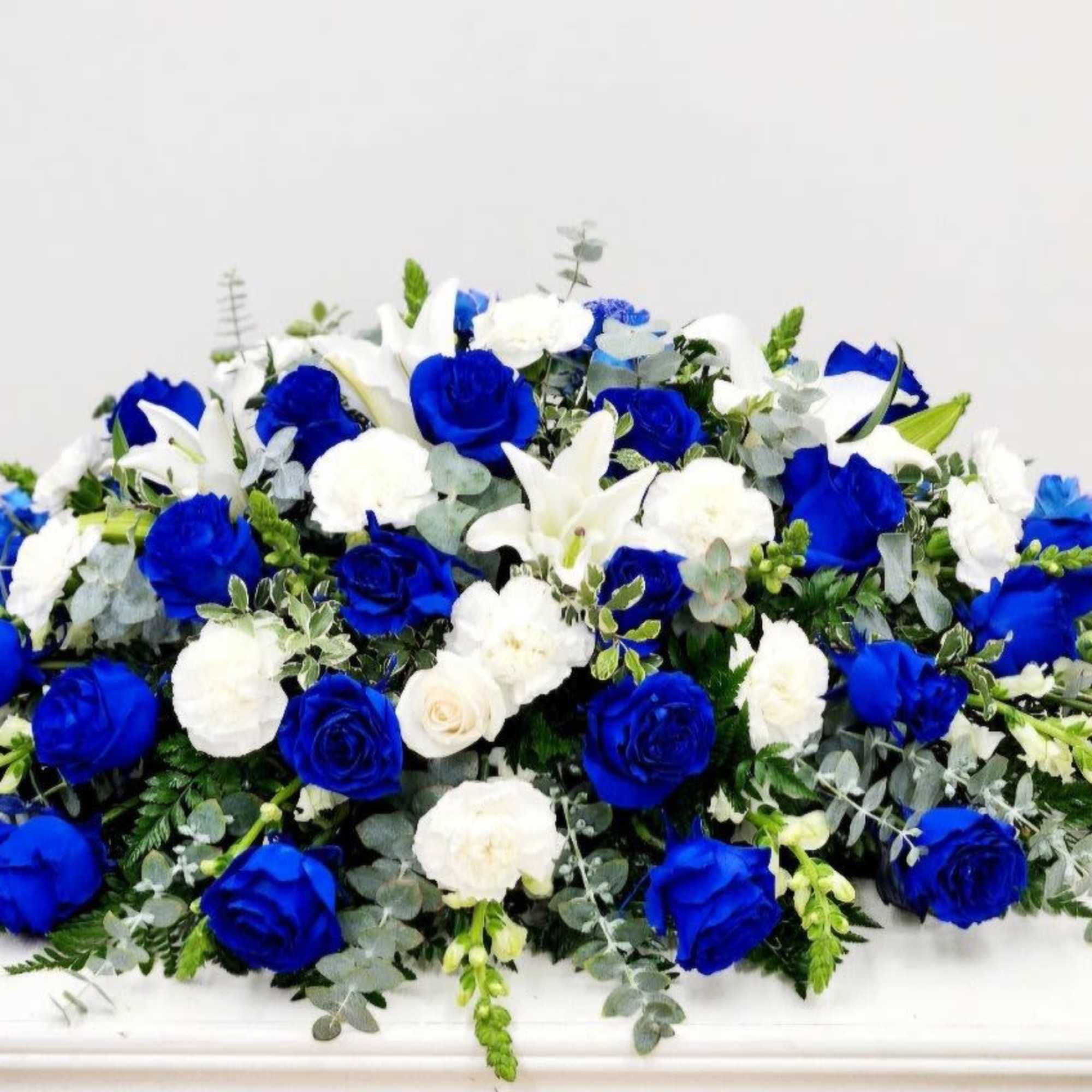 The Blue Horizon Casket Spray offers a beautiful tribute, blending hues of