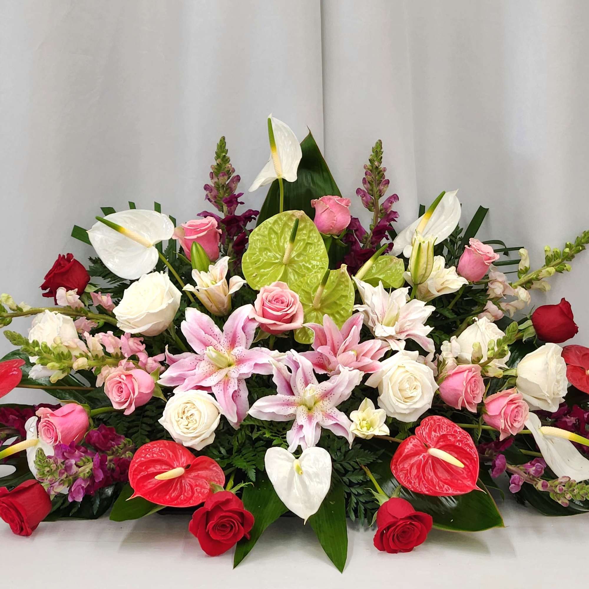 The Tropical Garden Casket Spray is a strong and unique tribute that