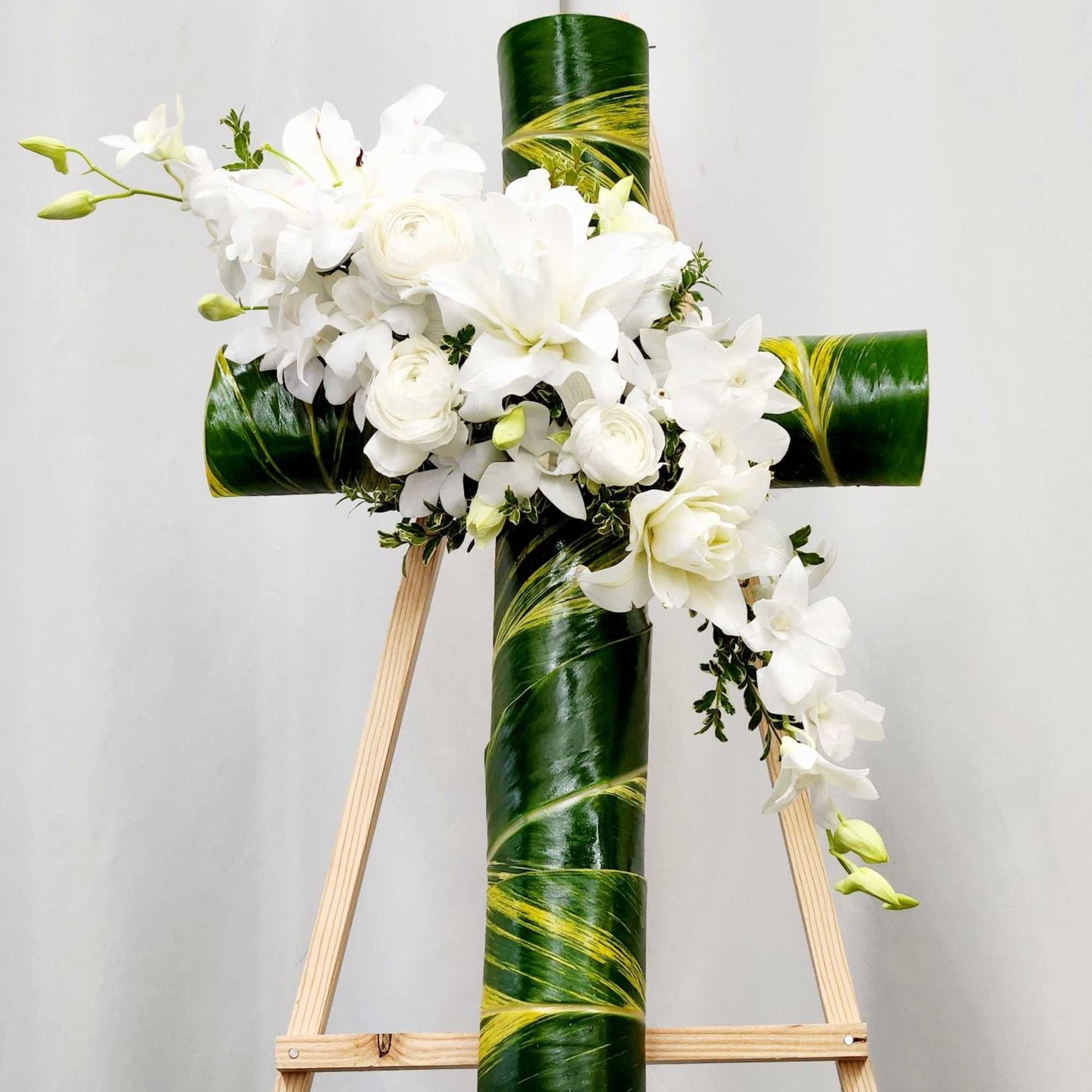 The Loving Memories Cross is a refined sympathy arrangement showcases a graceful