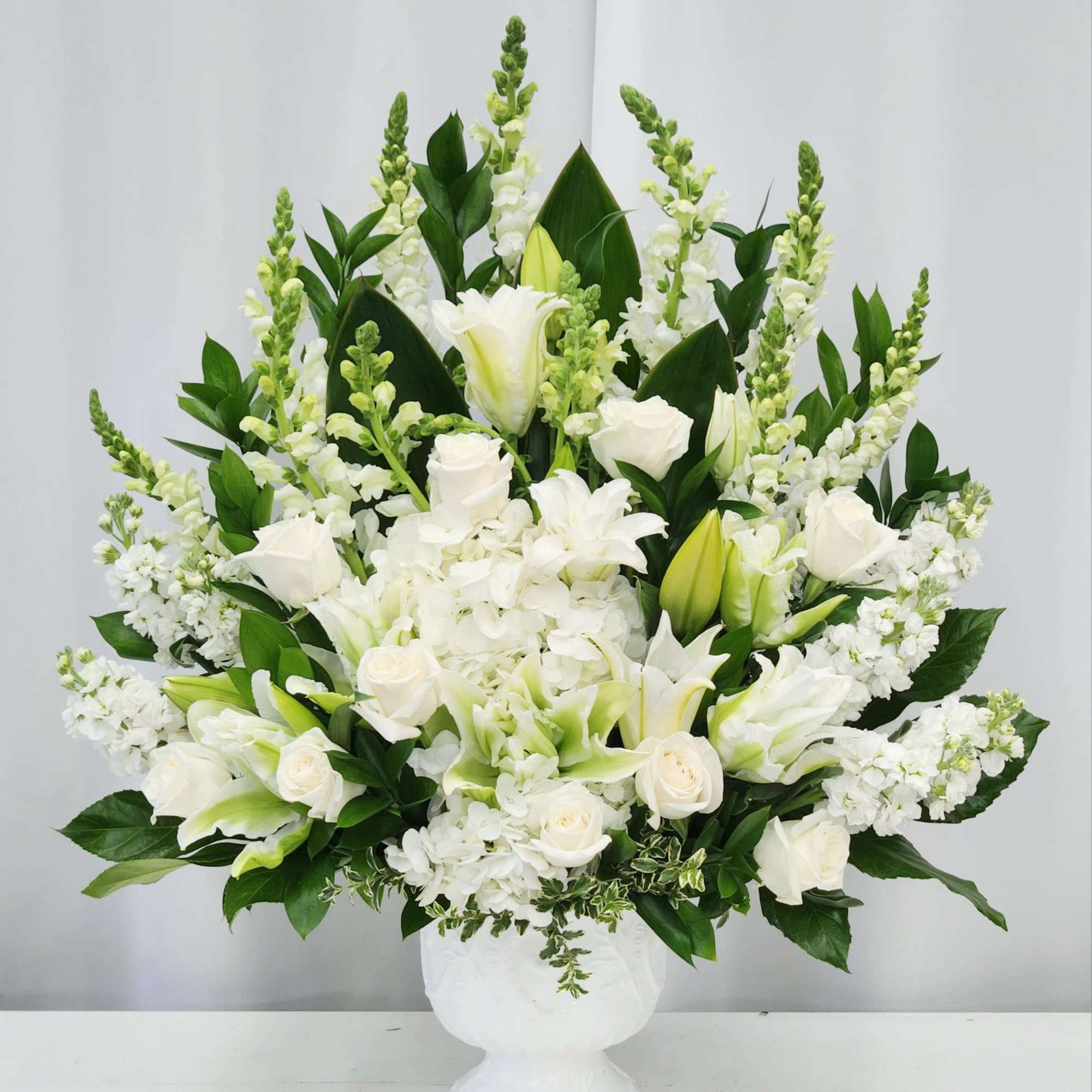 This elegant one-sided altar arrangement showcases graceful white lilies, roses and hydrengeas