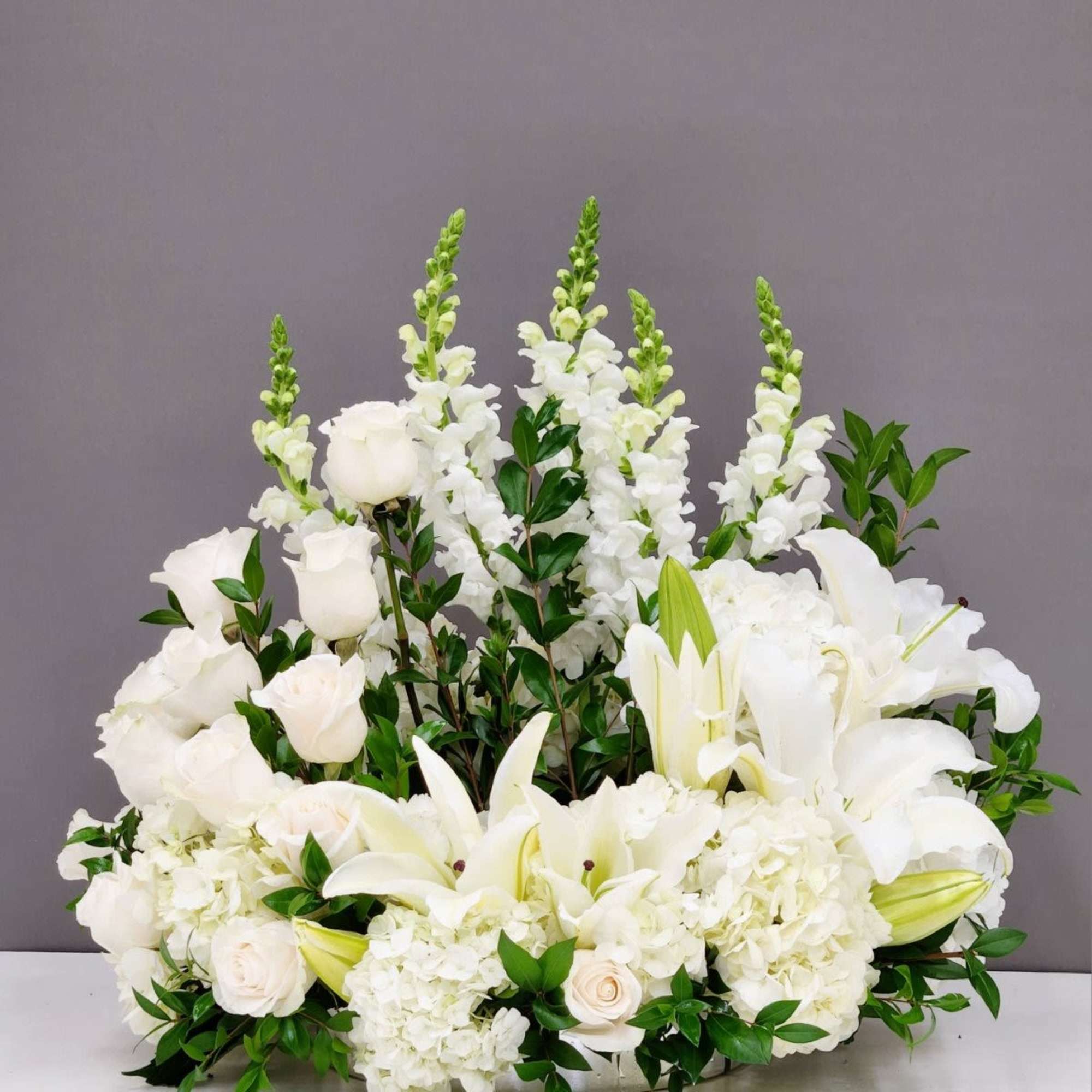 Peaceful Soul is a serene cremation arrangement crafted with pure white snapdragons