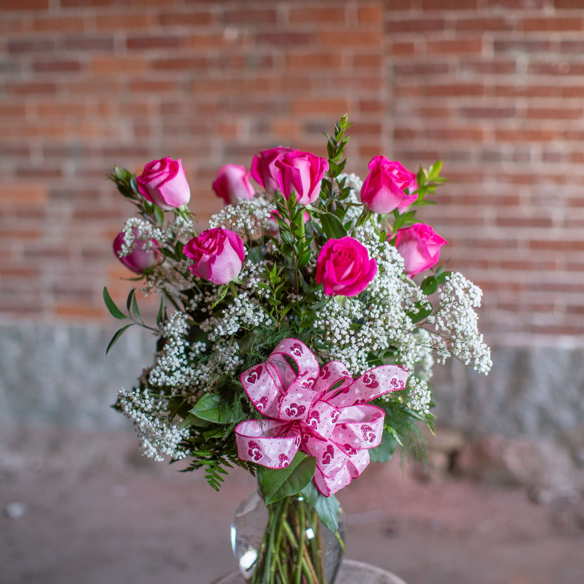 Pretty, premium long stem pink roses are arranged in an all around