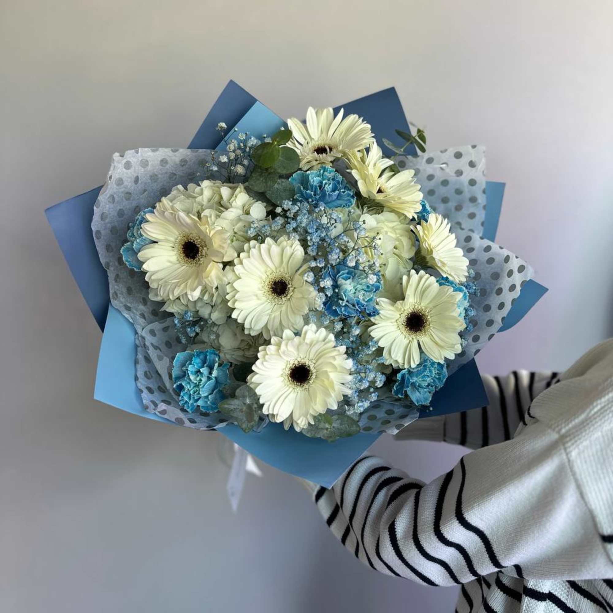 A fresh blue and white bouquet designed with hydrangea, gerberas, and delicate