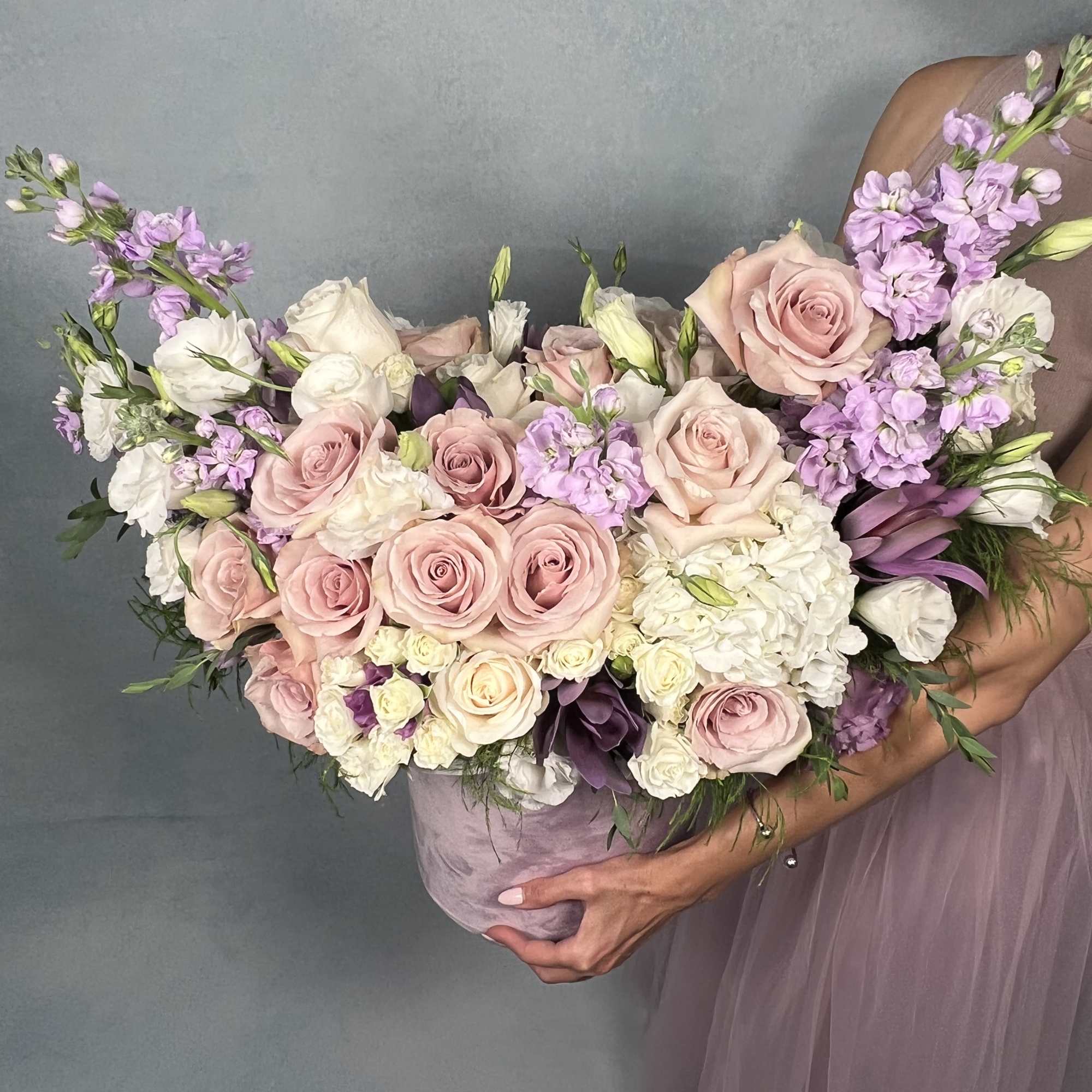 This elegant floral arrangement features a soft palette of blush pink roses