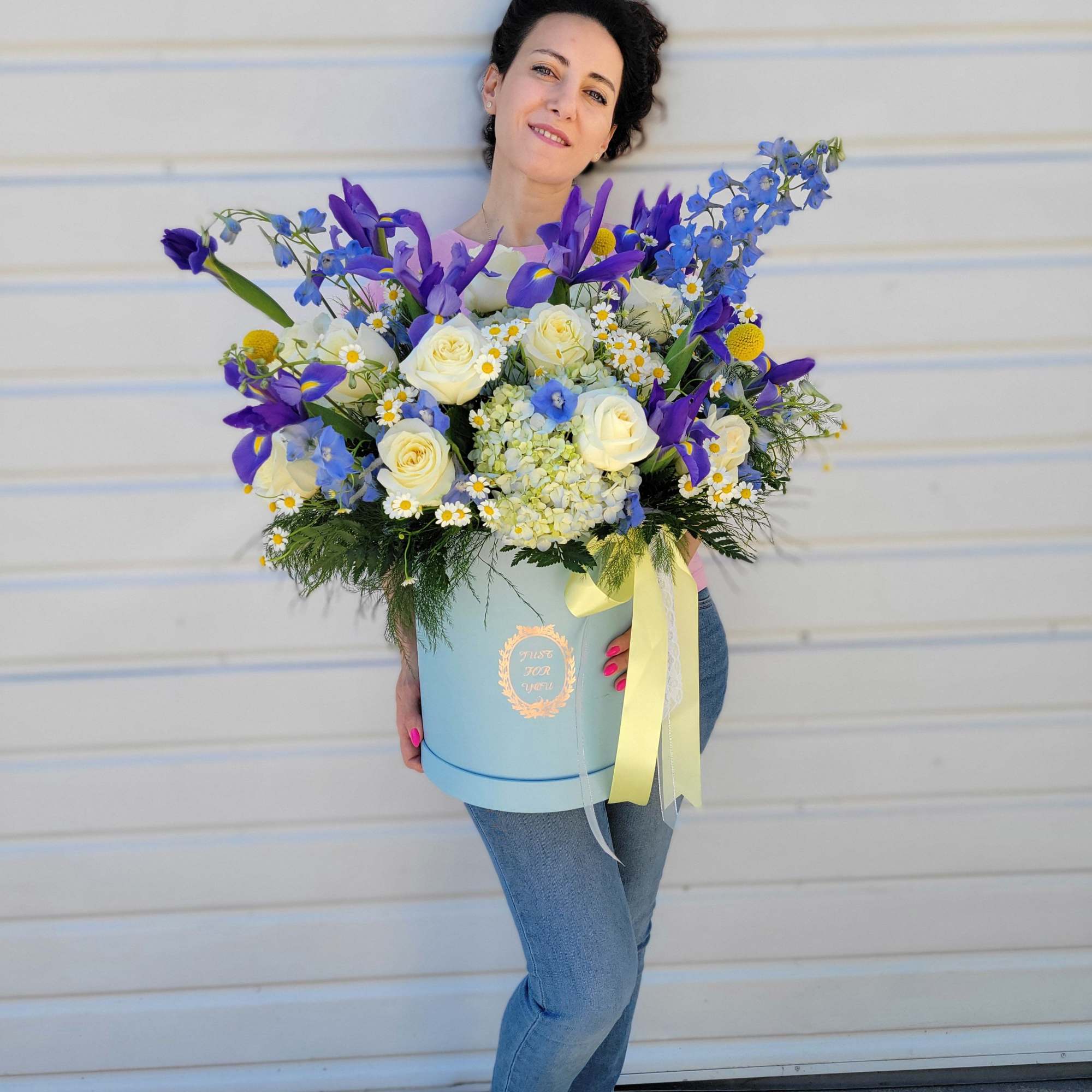 This vibrant flower arrangement combines cheerful Daisies, elegant Irises, romantic Roses, charming