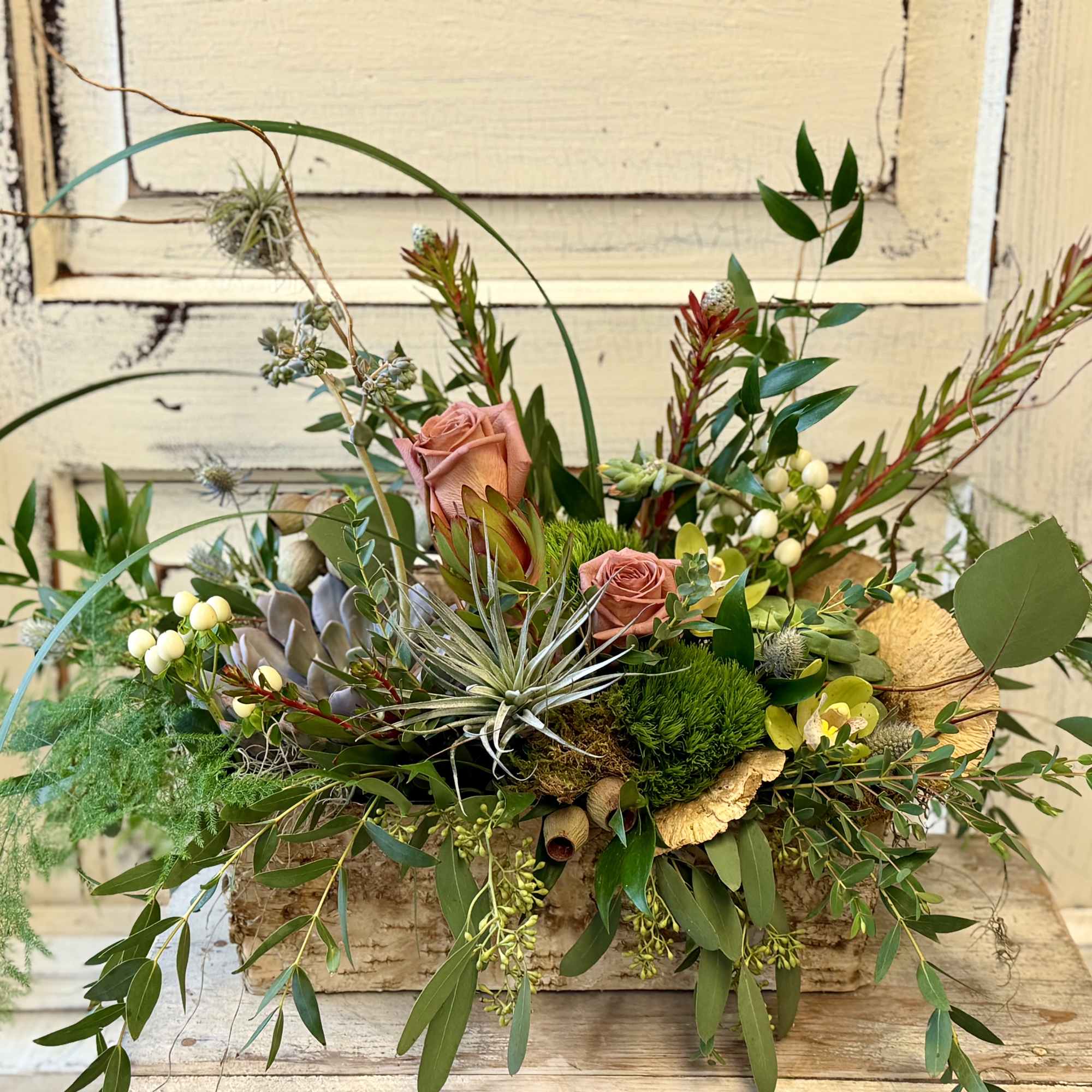 A metal tin or birch bark container is designed with an assortment