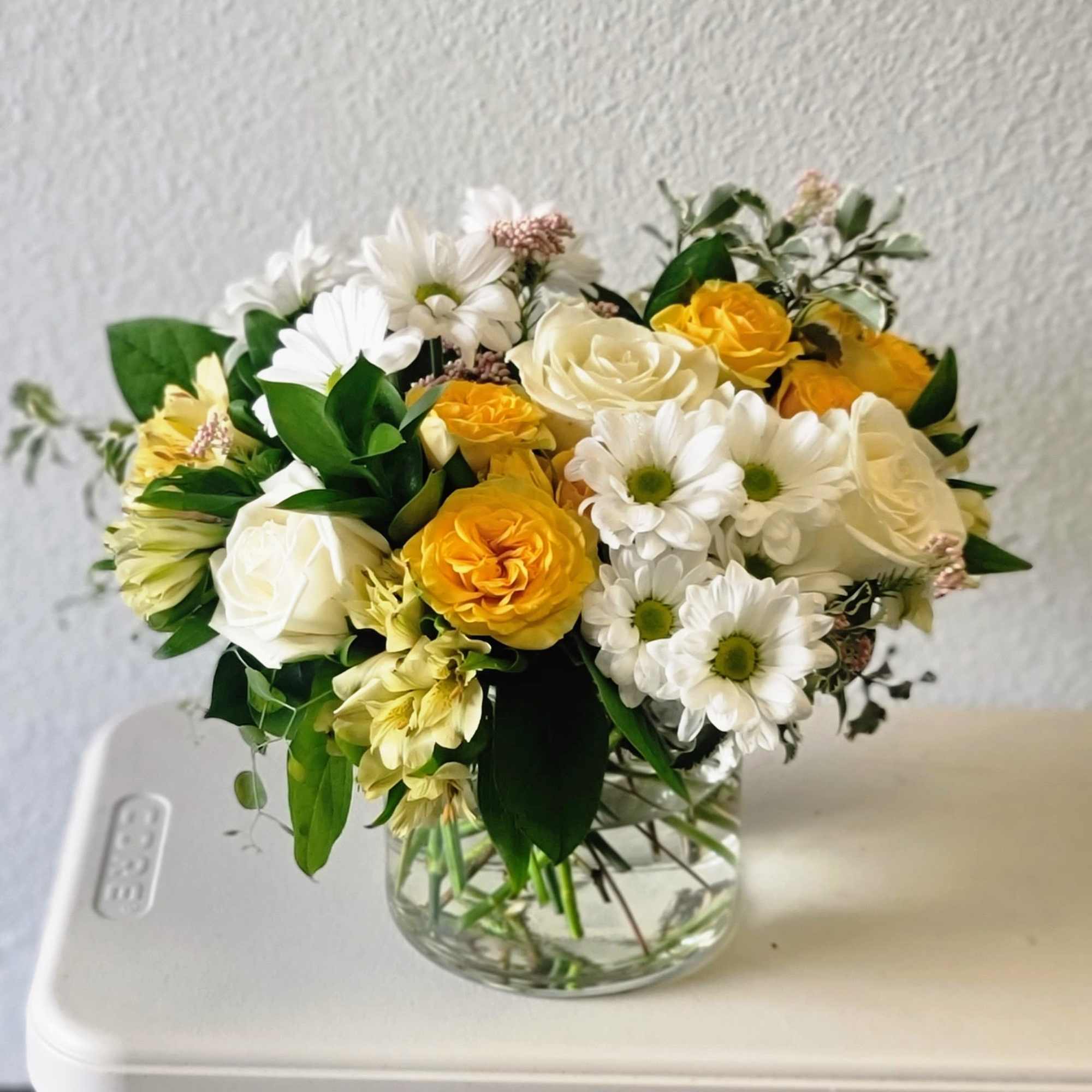 This uplifting bouquet features classic blooms in cheerful yellow hues to brighten