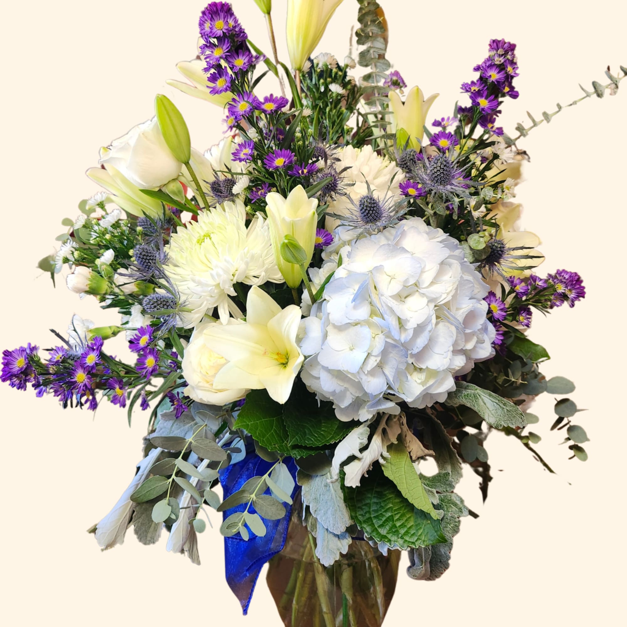 This peaceful arrangement includes roses, asiatic lilies, chrysanthemums, hydrangea, carnations, and other