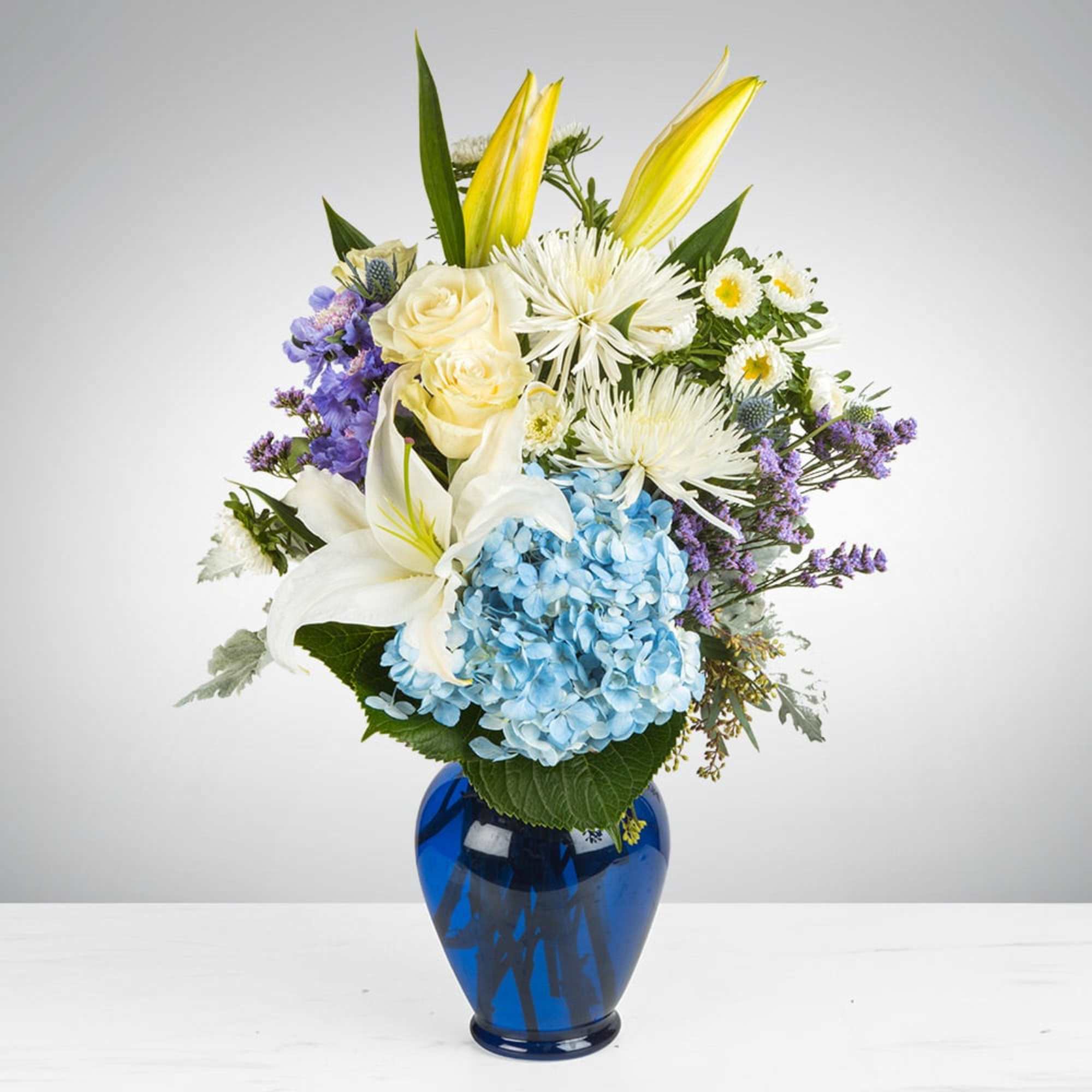 This peaceful arrangement includes roses, asiatic lilies, chrysanthemums, hydrangea, carnations, and other
