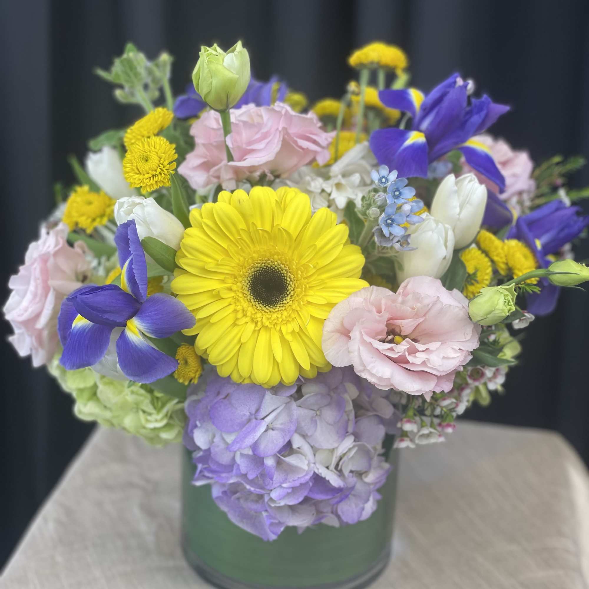 Mixed bouquet in a glass vase with yellow, pink, purple, and white blooms
