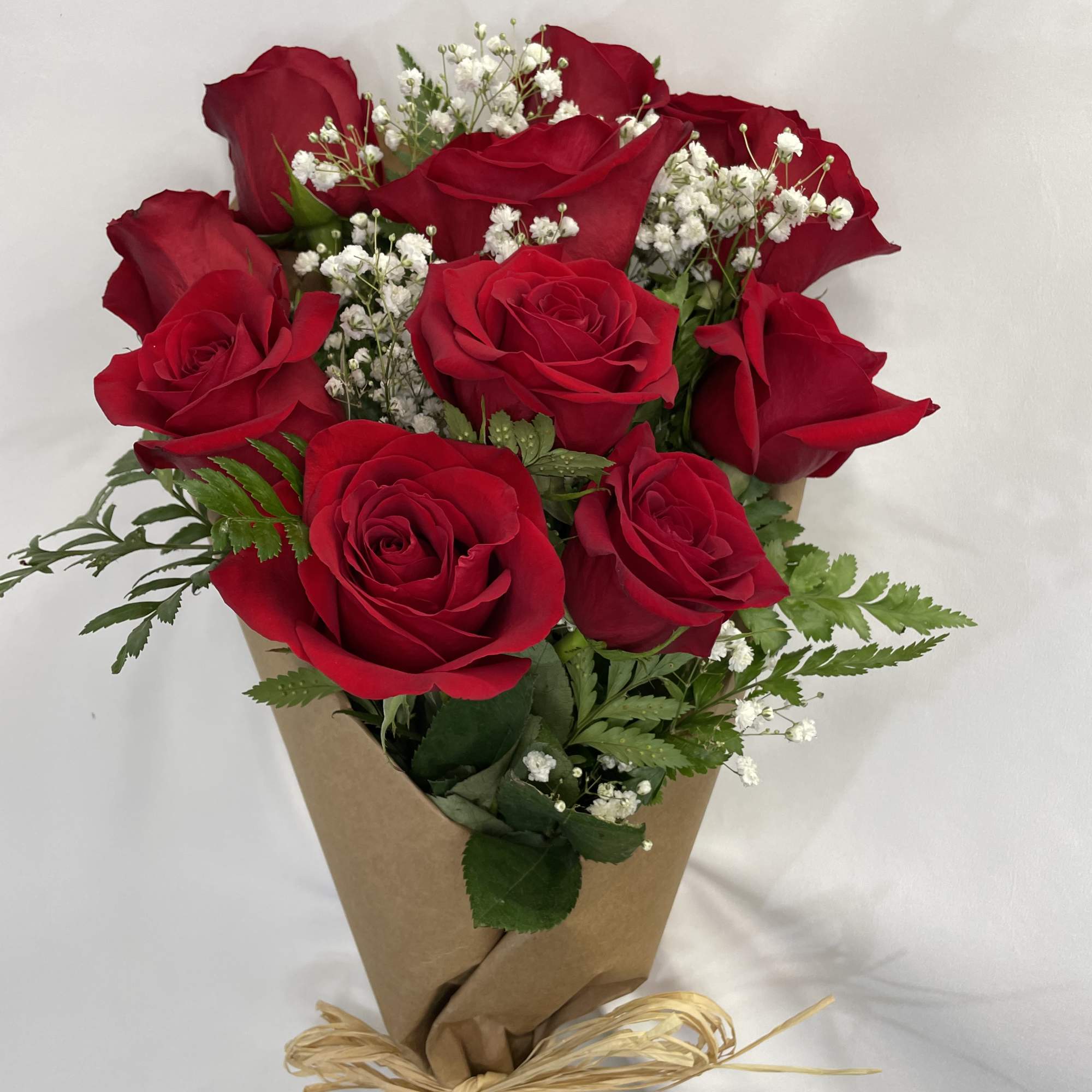 This Dozen Rose Bouquet is wrapped with paper and a bow. Arranged