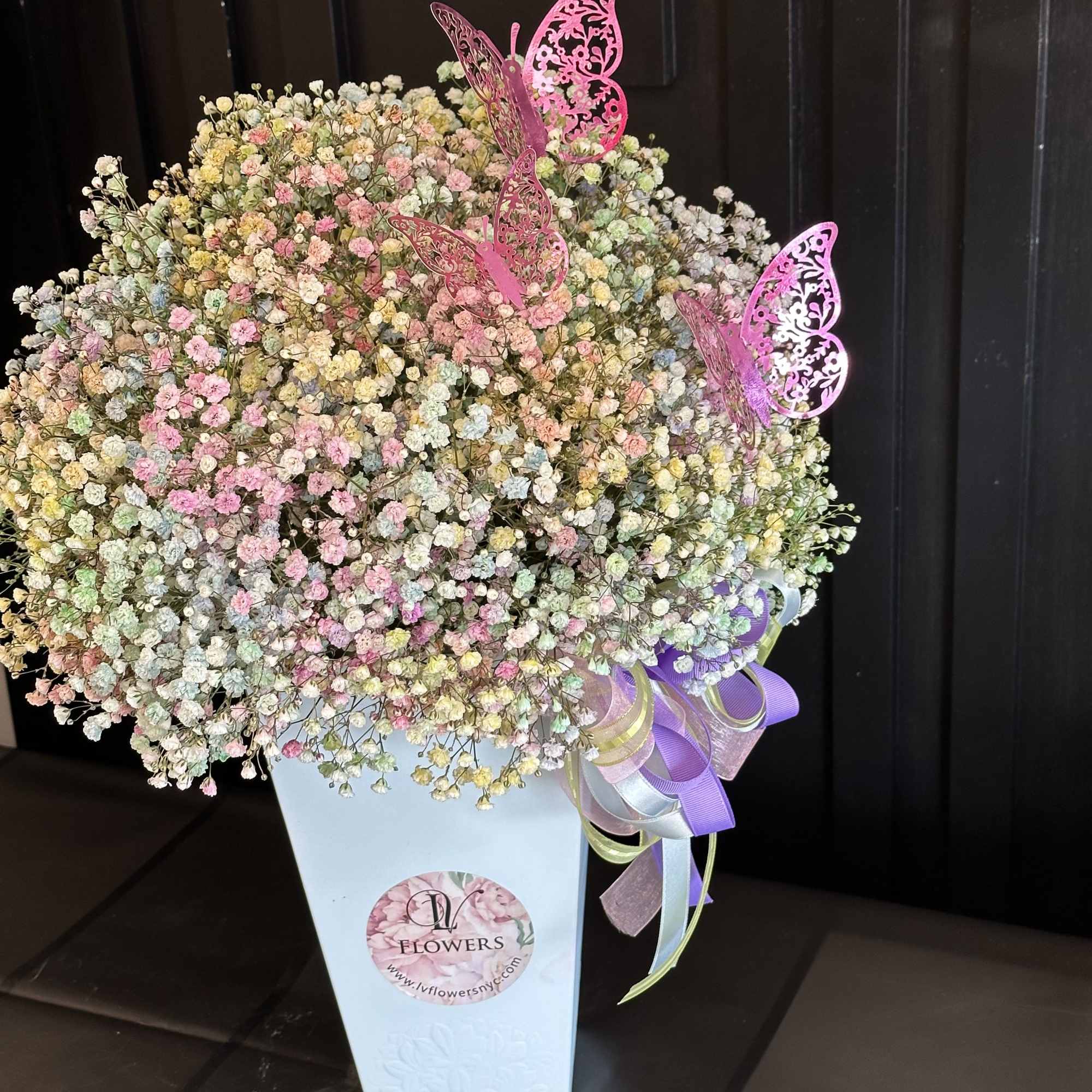 A tall arrangement filled with a bright colorful baby's breath wrapped in