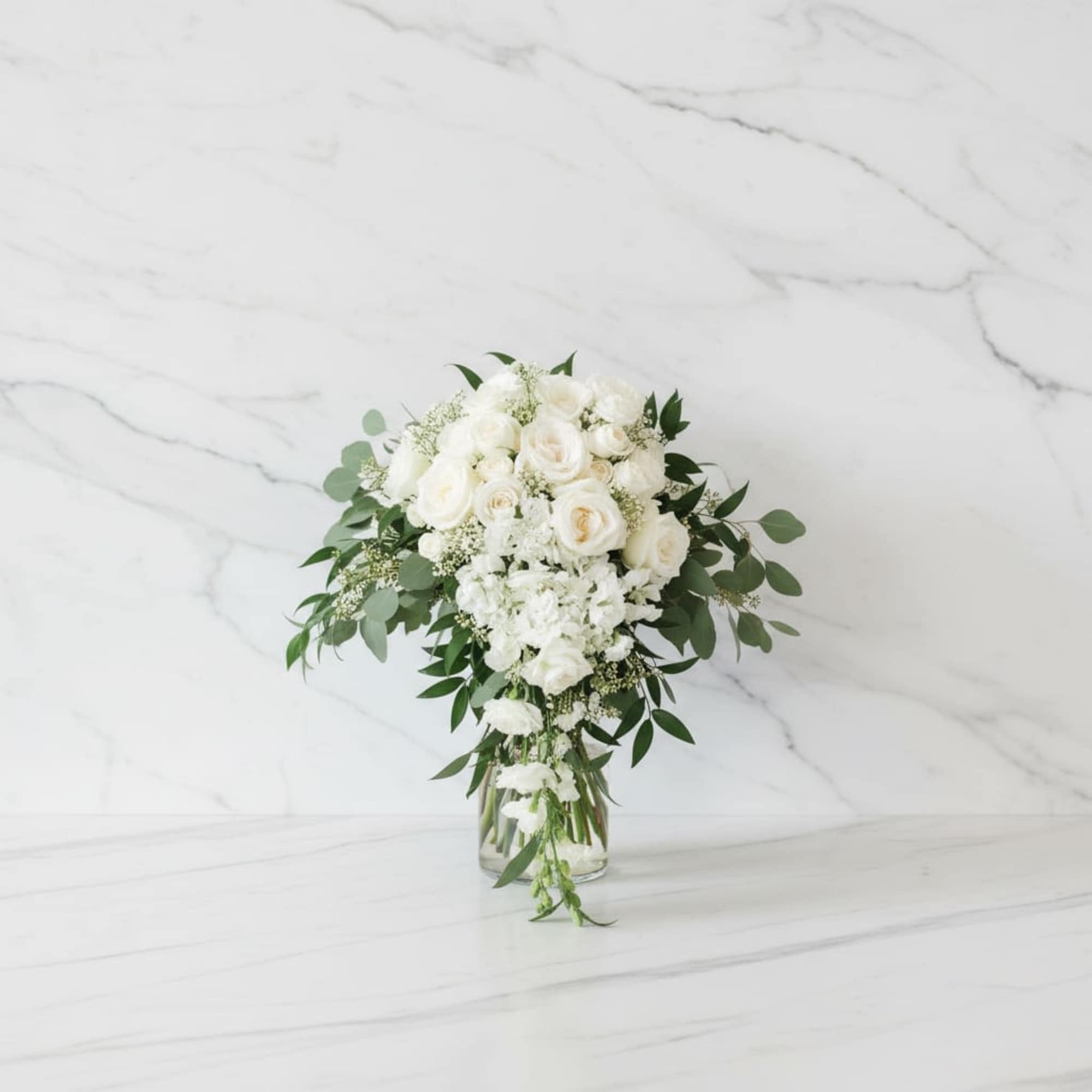 Hand-tied in a loose, flowing style, the bouquet showcases beautiful white roses