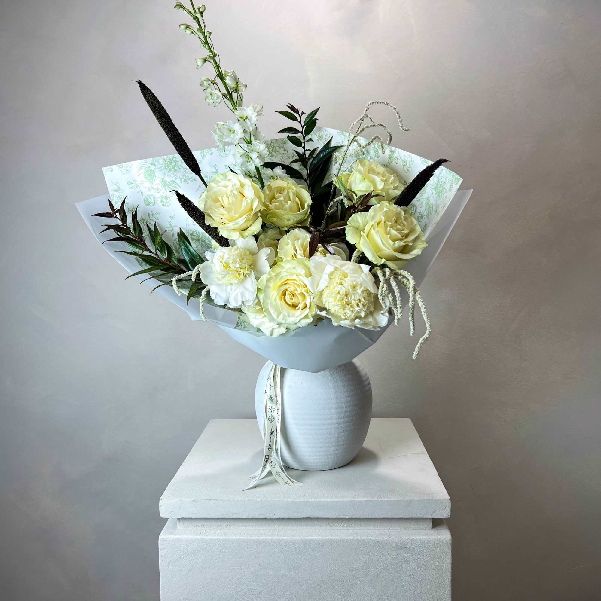 Bouquet of pale yellow and white flowers in a white vase